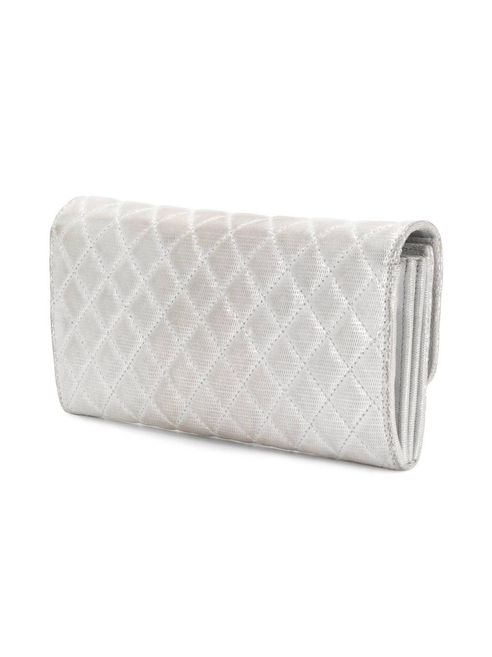 This metallic Chanel Bag featuring silver quilted suede is embellished at the front by the iconic Chanel CC monogram in silver-plated metal hardware. Opening with a zip, it features an interior with three spacious compartments. 

This bag comes with