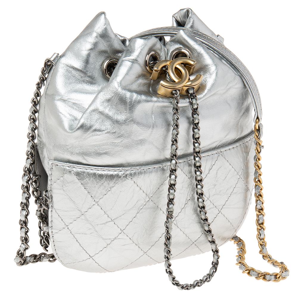 Made to ensure high quality and enduring appeal, this bag from Chanel will be your companion for years to come. Add a glamorous touch to your everyday casuals with this Gabrielle leather bucket bag. Lined with fabric and designed with a CC