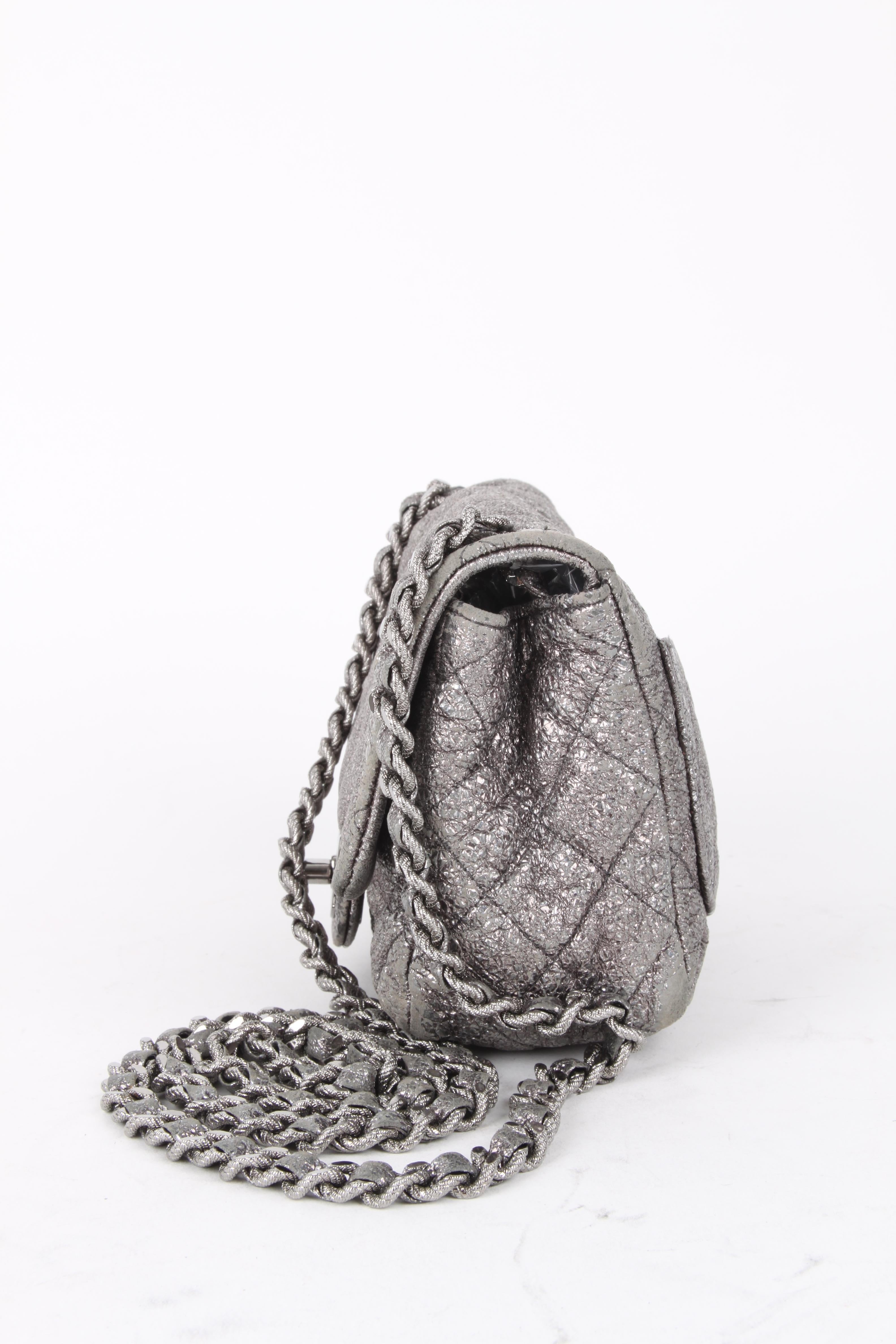 Chanel Silver Quilted Small Flap Crossbody Bag.

This little bag makes a big statement. It features a silver coated fabric exterior with matching iridescent grey leather woven handle. The bag features an grey leather lining, CC-logo fastening