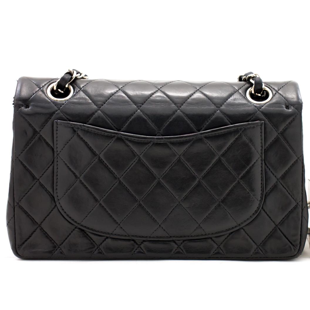 The perfect everyday bag, this iconic pre-owned black diamond quilted lambskin 9-inch double flap bag from 2000-2002 features the classic  'CC' turn-lock closure, which opens to reveal a small zip pocket and an additional internal compartment. There