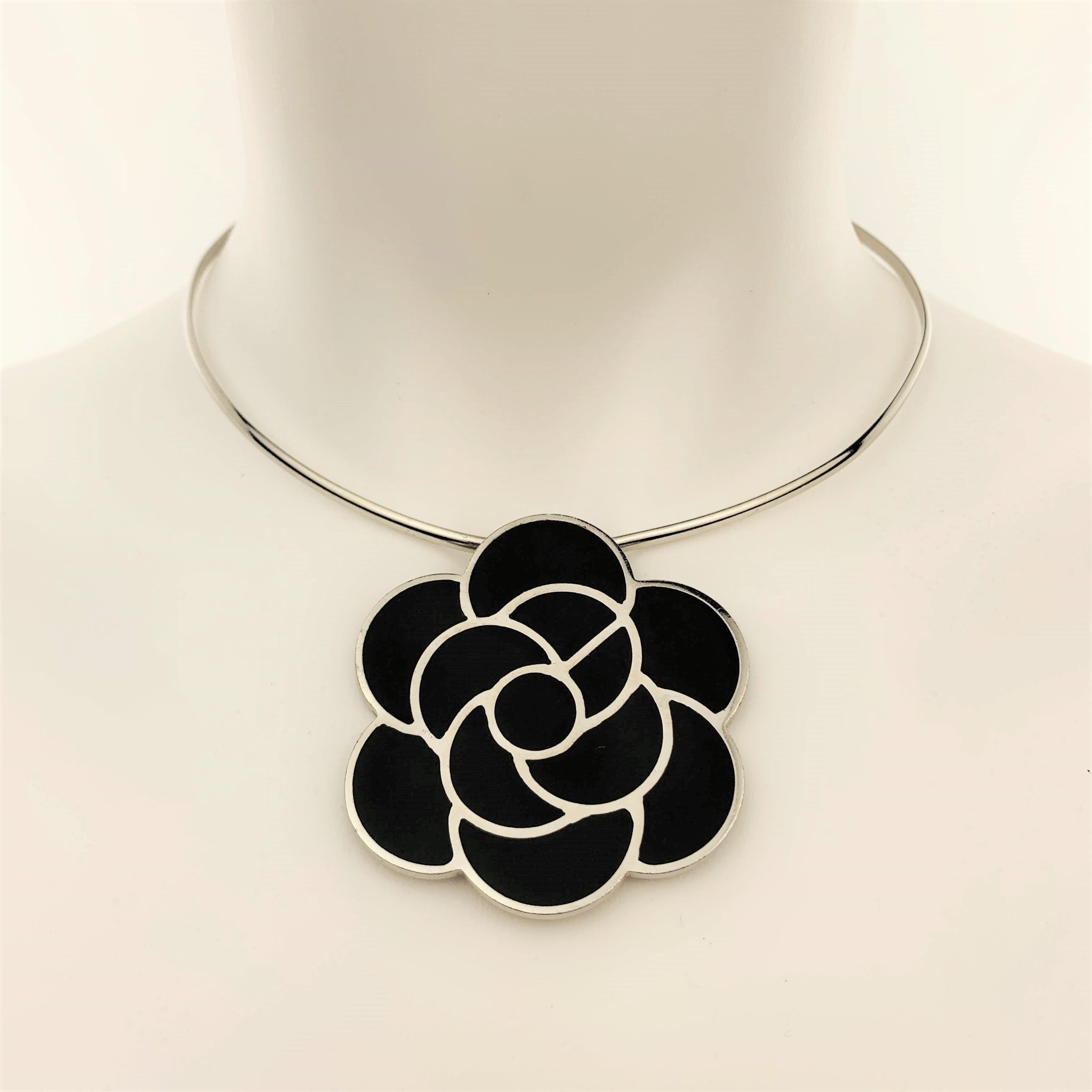 Vintage CHANEL circa 1998 choker necklace features a stiff silver tone metal necklace with chain closure back and black enamel Camellia pendant. Made in France.
 
Very Good Pre-Owned Condition.
Marked: 98 P
 
Necklace: 15 in.
Pendant: 5 x 5 cm.