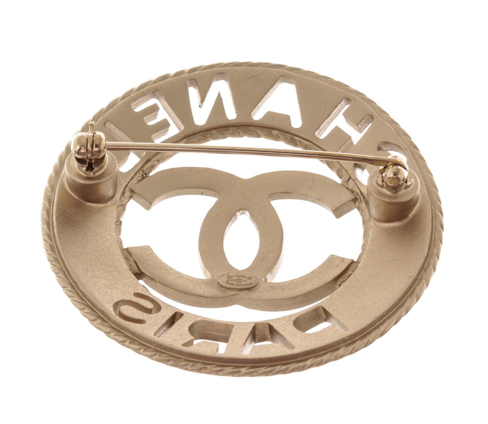 Chanel Silver-tone Metal CC Paris Round Brooch features interlocking CC logo at the center and silver-tone hardware.

54074MSC