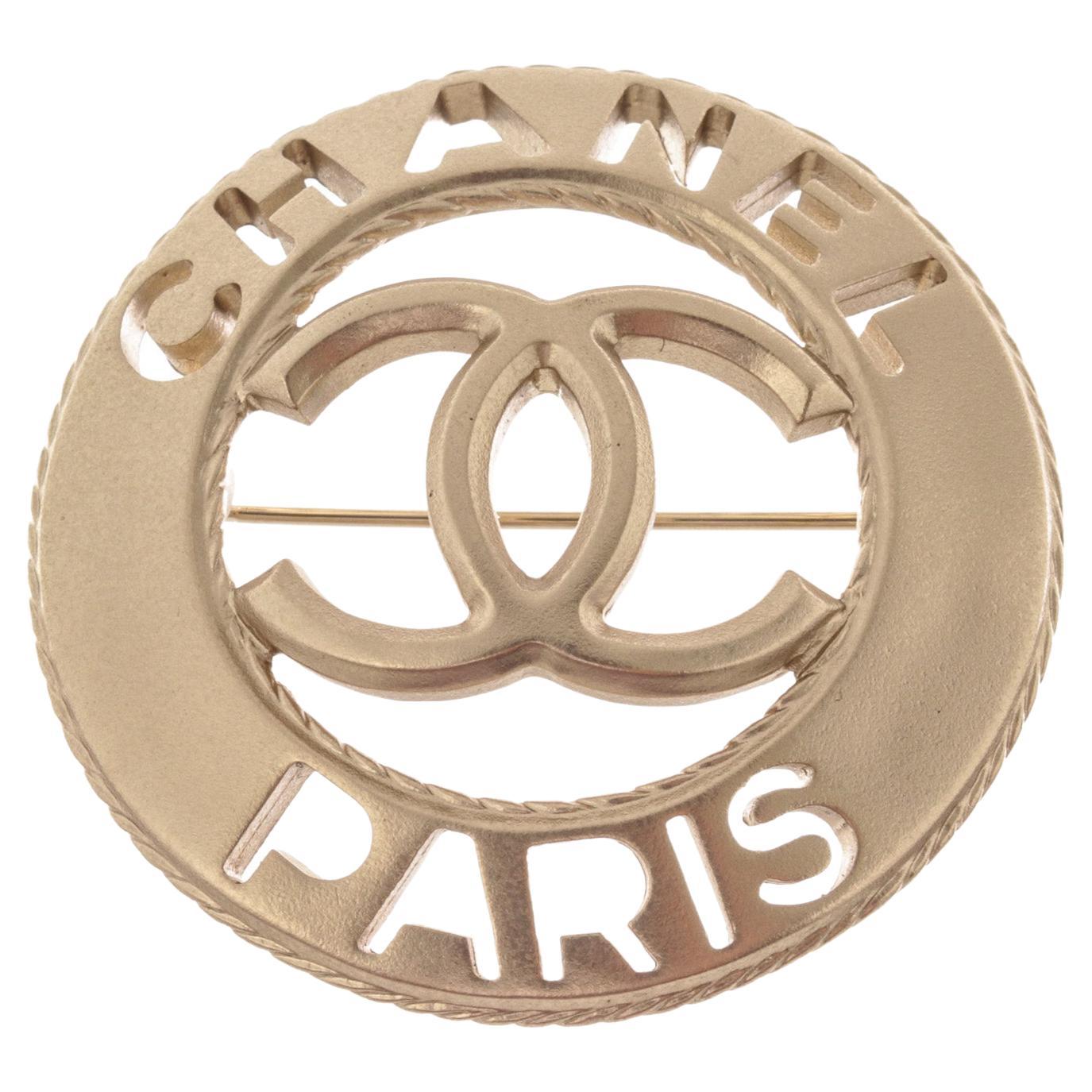 Broche ronde en métal argenté CC Paris de Chanel en vente