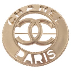 Broche ronde en métal argenté CC Paris de Chanel