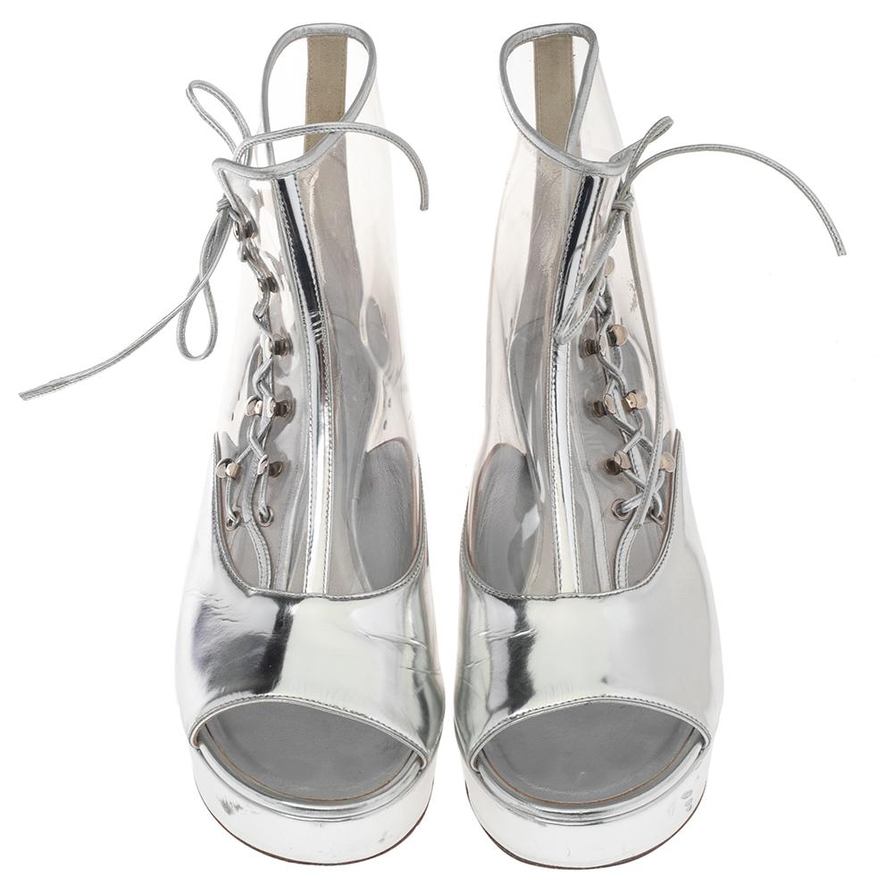 Emit luxurious vibes as you wear these classy Chanel ankle boots. They are designed using silver-transparent leather and PVC on the exterior and flaunt a lace-up detail on the vamps, open-toes, and block heels. They are embellished with silver-toned