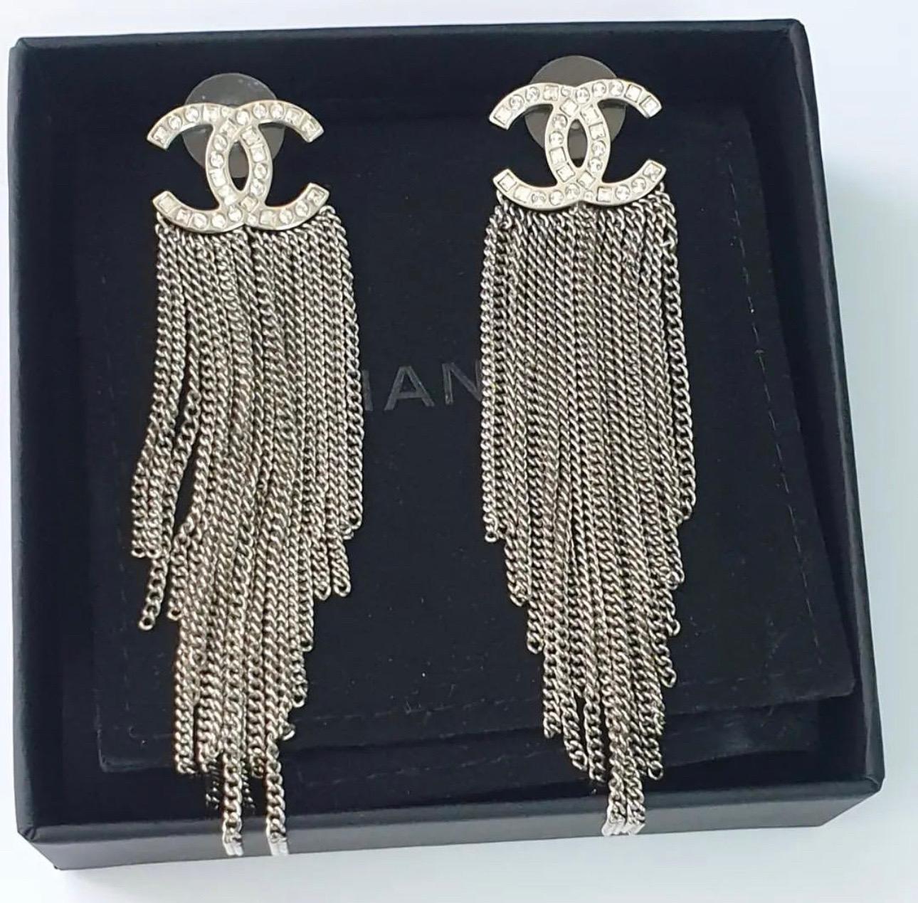 Glamorous and sophisticated, these Chanel earrings are a must-have accessory. Each earring consists of CC's with sparkling crystals with dangling fringe silvertone chains. Don't miss out on your opportunity to own these fabulous earrings.

Total
