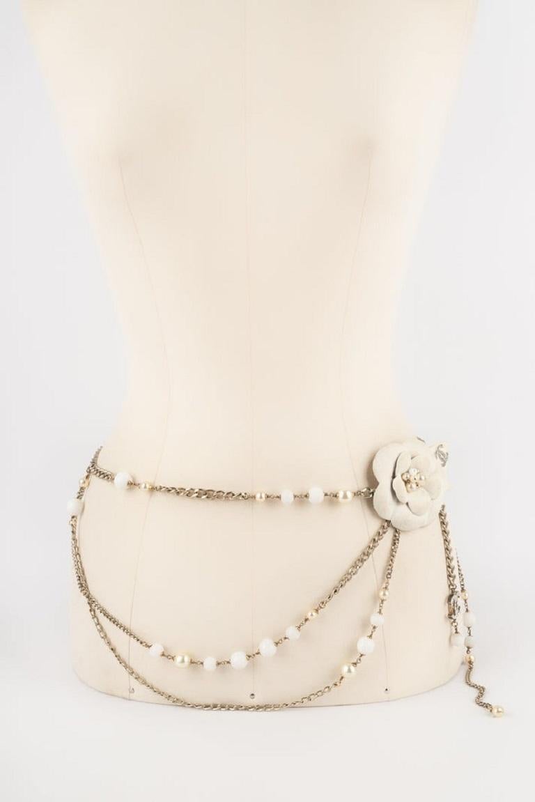 CHANEL - (Made in France) Silvery metal camellia belt with costume pearls, and snow-like pearls. The belt buckle is also sprayed to look like snow. 2005 Fall-Winter Collection. To be mentioned, the buckle has some dirty marks and the tiny costume