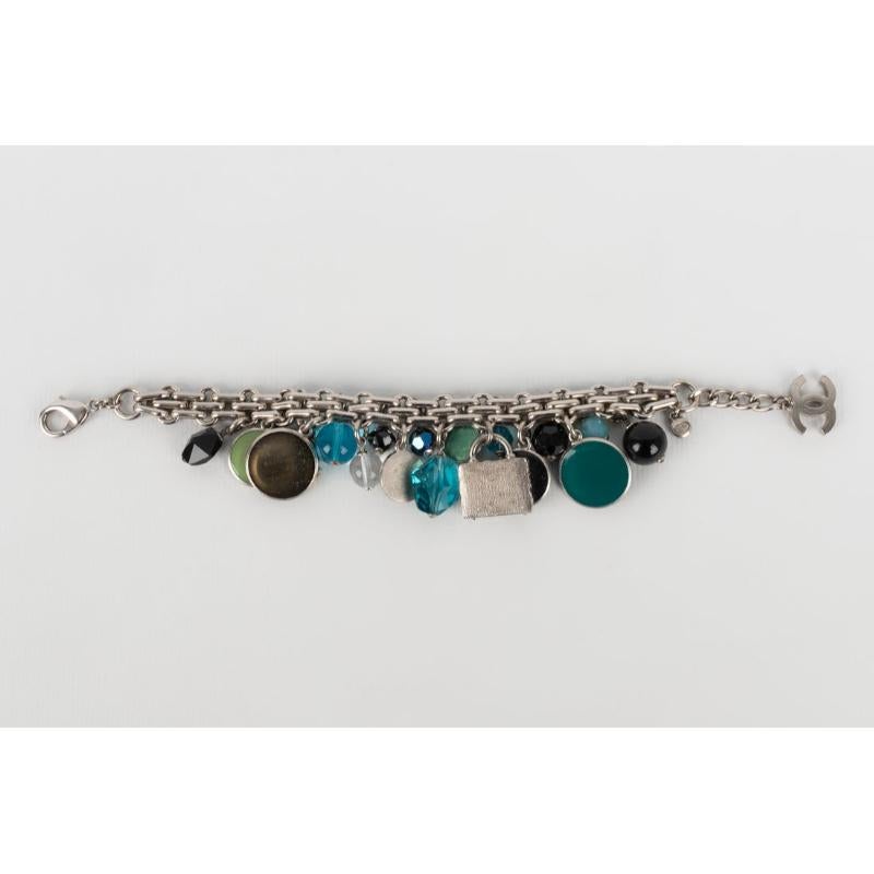 Chanel - (Made in France) Silvery metal bracelet ornamented with blue and green tone charms. Cruise 2007 Collection.

Additional information:
Condition: Very good condition
Dimensions: Length: from 18 cm to 20 cm
Period: 21st Century

Seller
