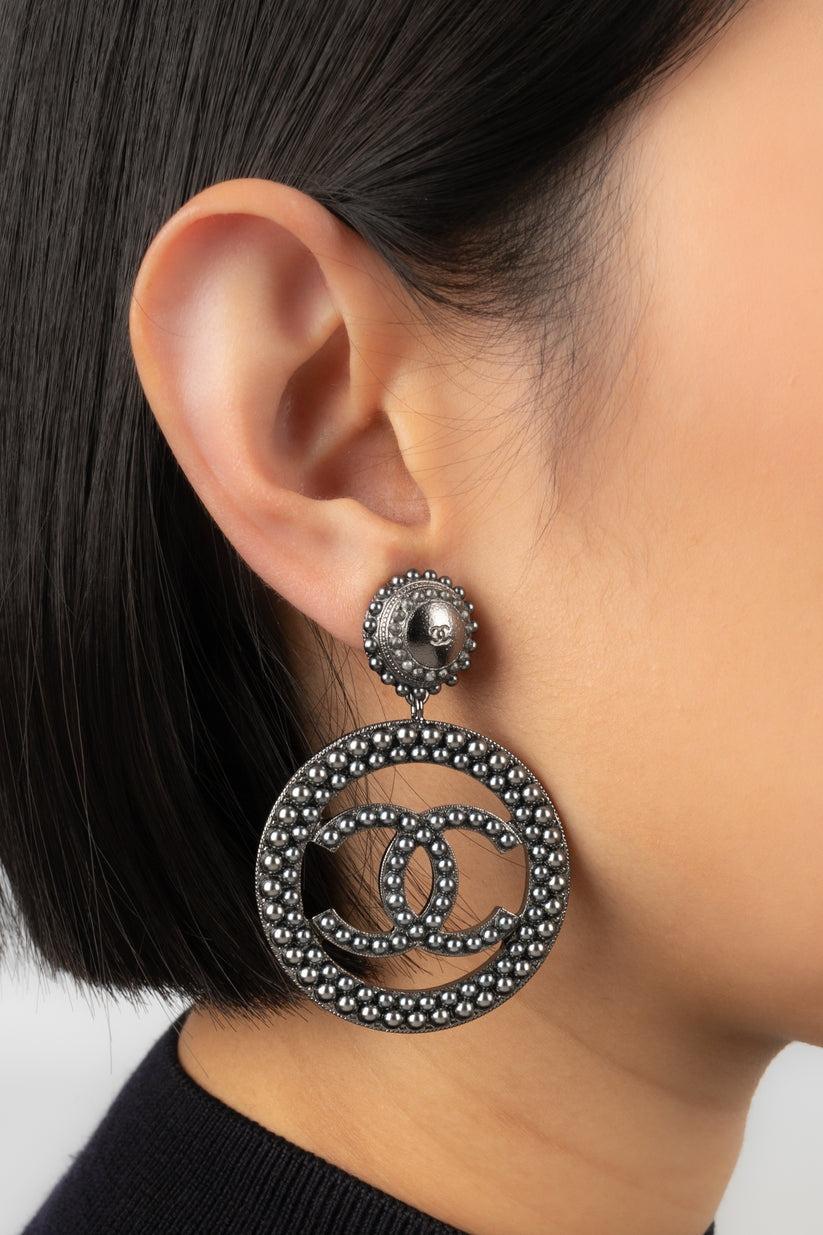 Chanel - (Made in France) Silvery metal clip-on earrings ornamented with grey pearly cabochons. 2017 Collection.

Additional information:
Condition: Very good condition
Dimensions: Height: 6.5 cm
Period: 21st Century

Seller Reference: BOB258