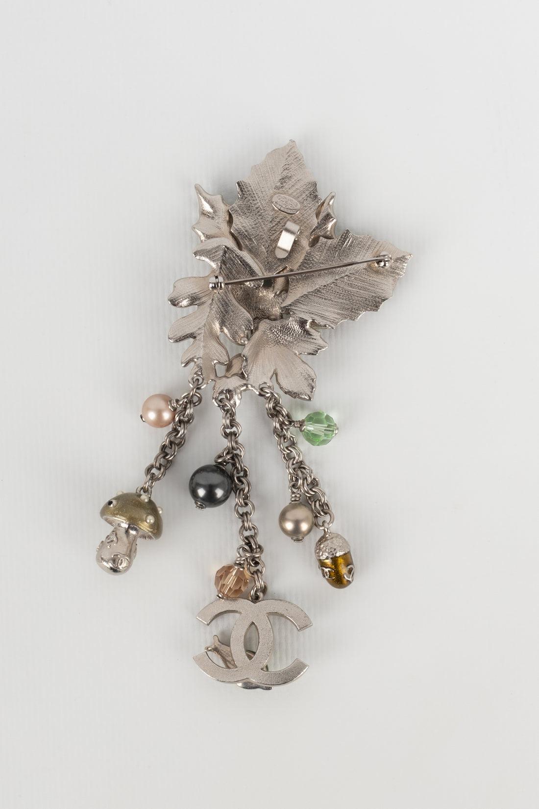 Chanel - (Made in France) Silvery metal pendant brooch with enamel, rhinestones, pearls, and charms. Fall-Winter 2005 Collection.

Additional information:
Condition: Very good condition
Dimensions: Height: 13 cm
Period: 21st Century

Seller