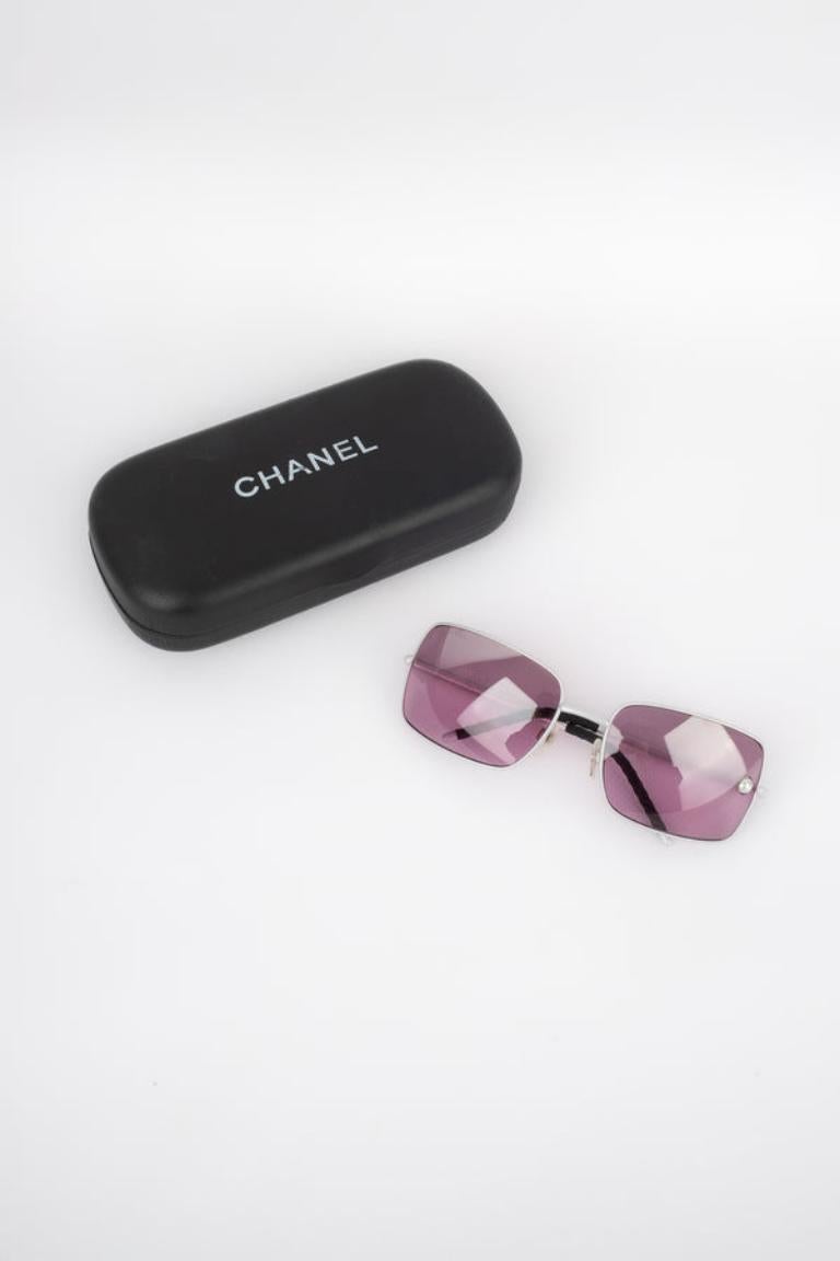 Chanel - (Made in Italy) Lunettes de soleil en métal argenté avec verre teinté. 

Informations complémentaires : 
Condit : Bon état
Dimensions : Longueur : 13.5 cm

Référence du vendeur : ACC144