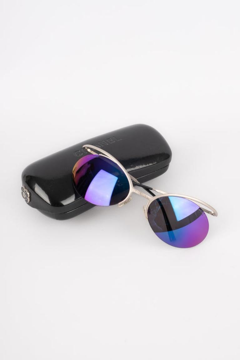 Chanel - (Made in Italy) Silvery metal sunglasses with tinted glasses in blue and purple tones.

Additional information:
Condition: Very good condition
Dimensions: Length: 15 cm

Seller Reference: ACC160