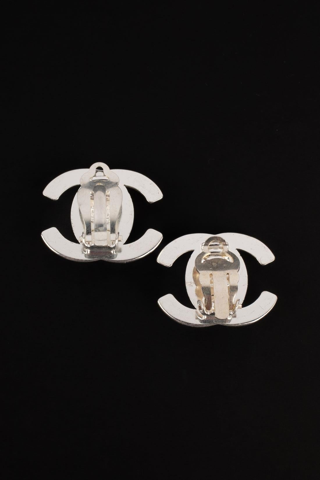 Chanel - (Made in France) Silvery metal turnlock earrings. 1997 Fall-Winter Collection.

Additional information:
Condition: Very good condition
Dimensions: Height: 2 cm
Period: 20th Century

Seller Reference: BOB232