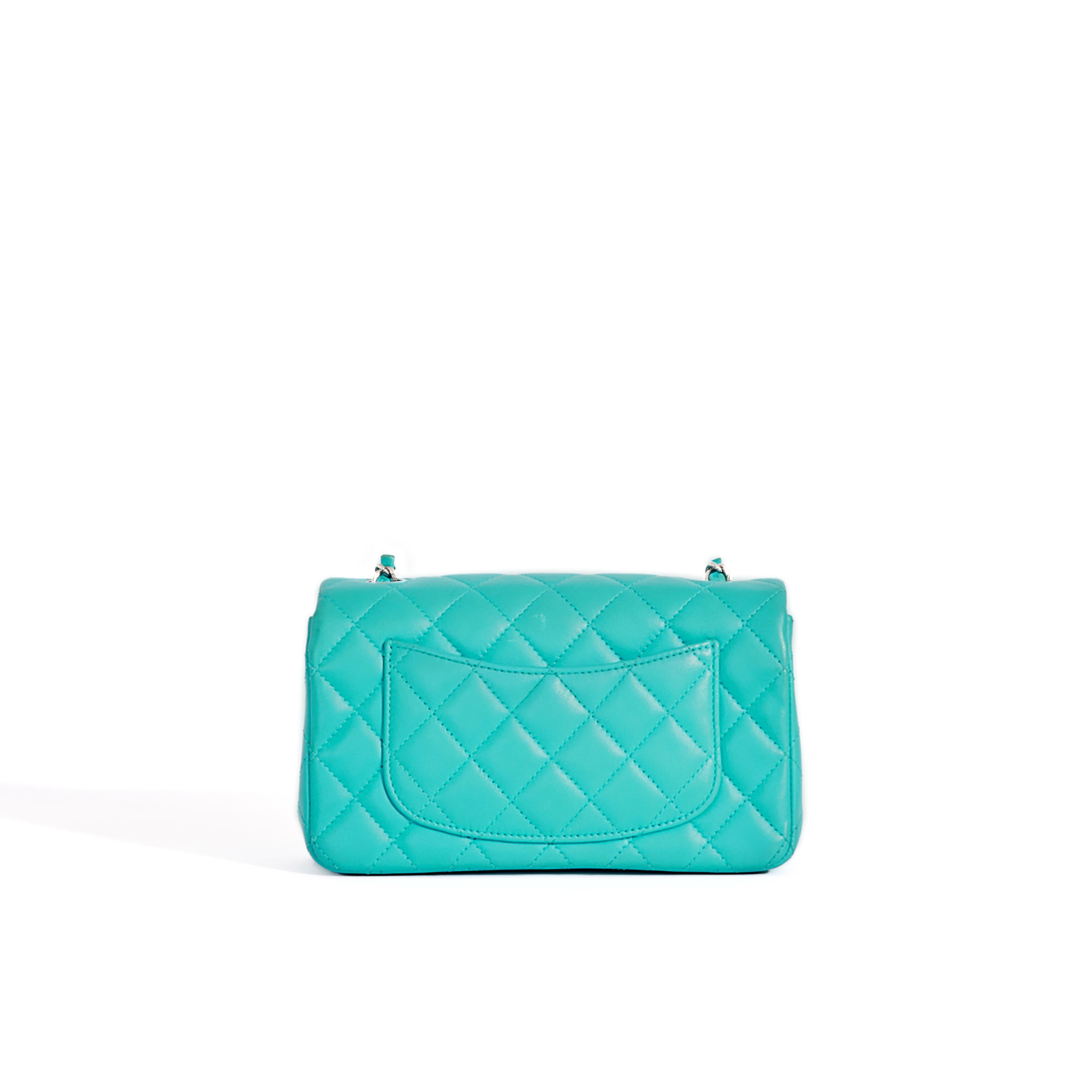 This turquoise quilted lambskin version with signature quilting features a single front flap and the CC logo turn-lock clasp on the front. 

The silver metal hardware includes the famous woven single chain strap which is perfect for wearing as a
