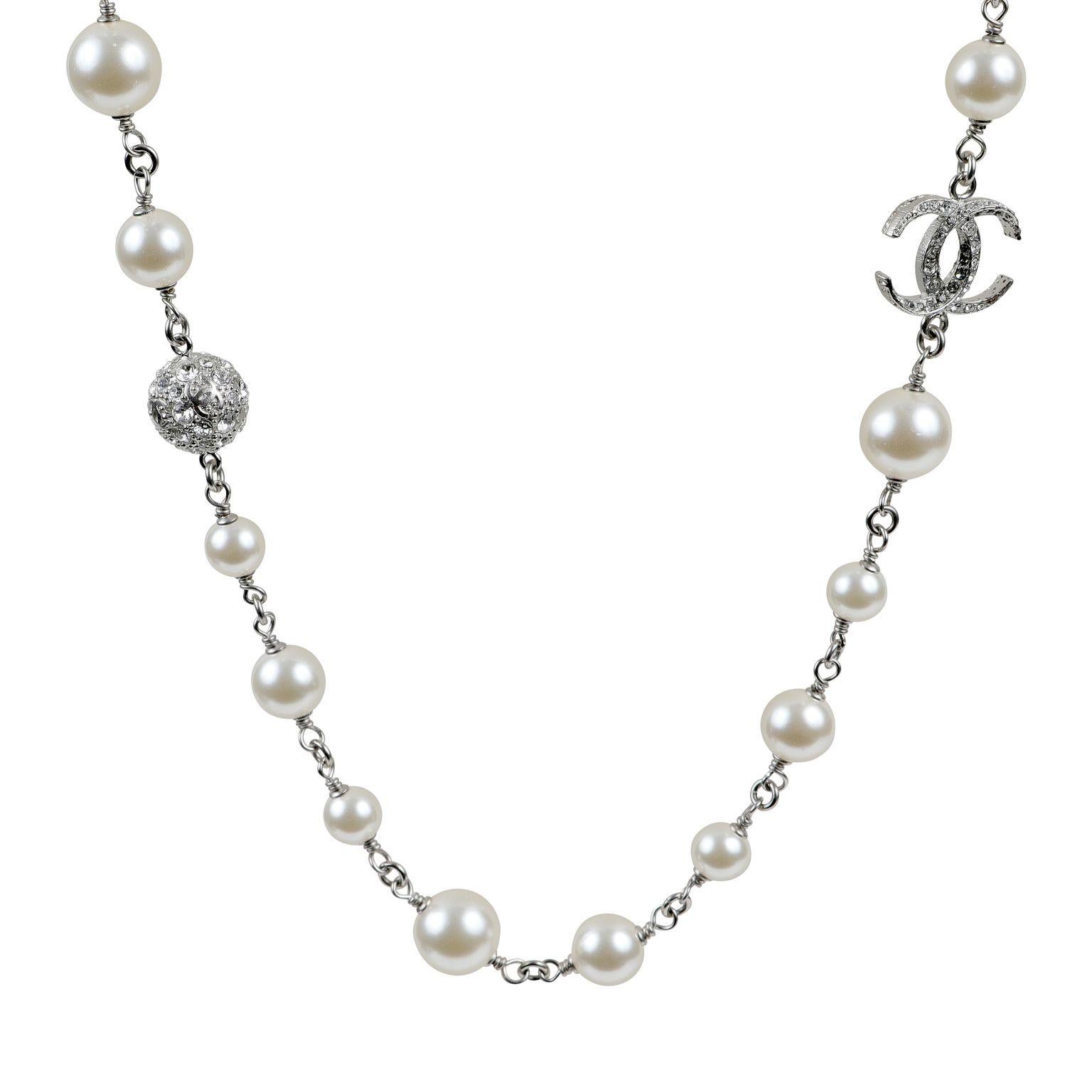 This authentic. Chanel Pearl and Crystal CC Necklace is pristine.  Single strand of white faux pearls with silver.  Crystal interlocking CC and spheres interspersed along the chain.  Pouch or box included. 

ACO 13942
