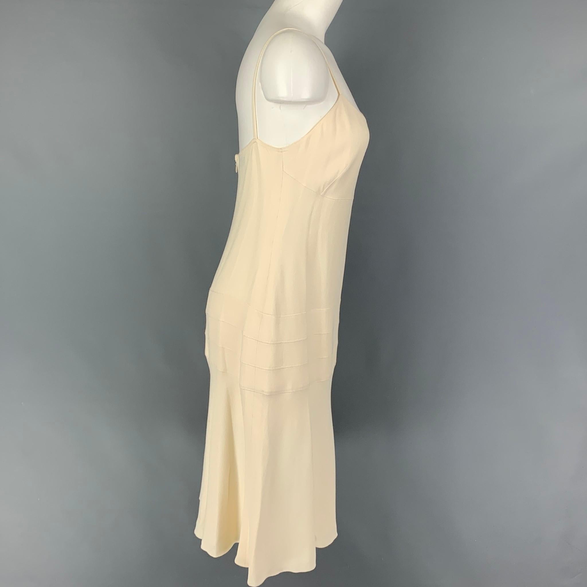 CHANEL 2003 dress comes in a cream crepe acetate / viscose featuring spaghetti straps, small silver tone logo emblem, and a back zipper closure. Made in France. 

Very Good Pre-Owned Condition.
Marked: 03P / AI284 42

Measurements:

Bust: 32