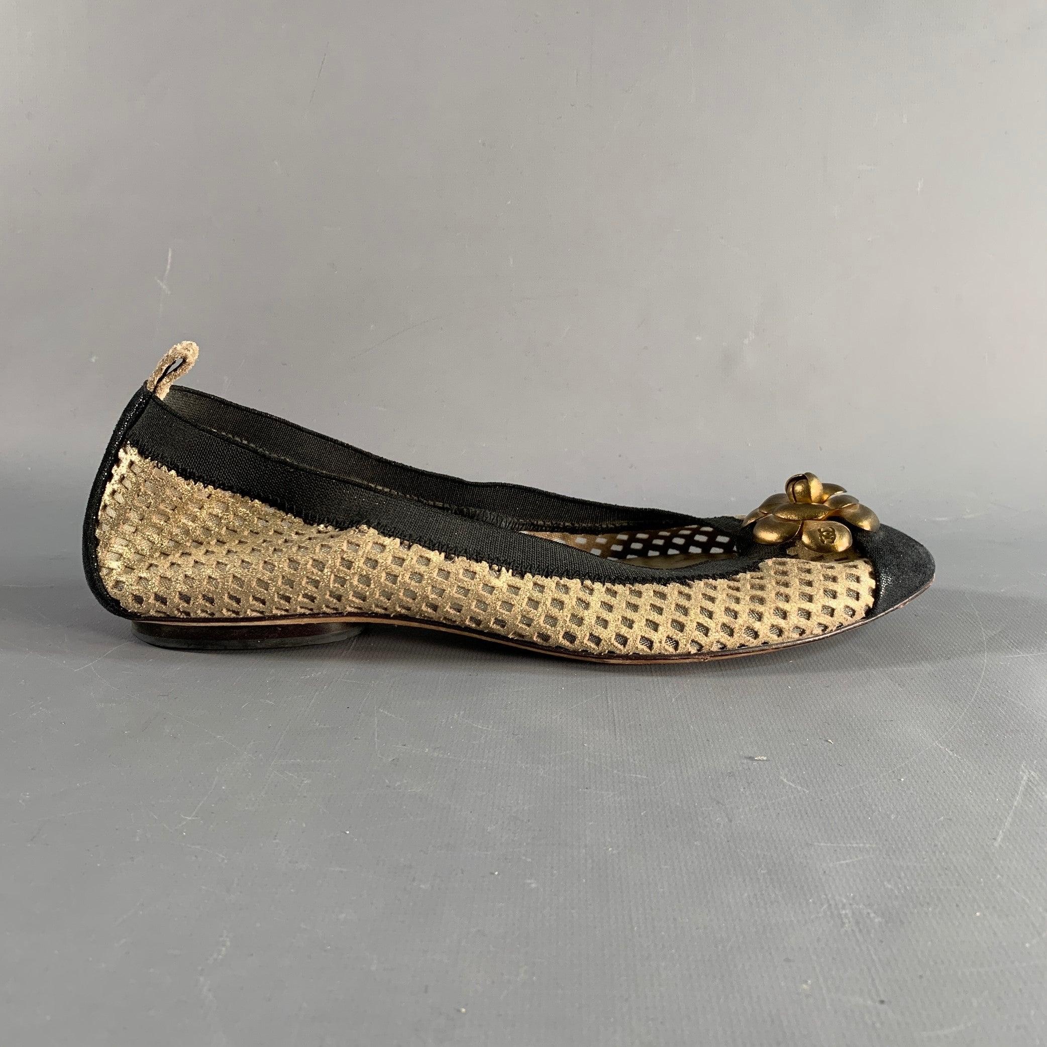 CHANEL ballet flats in a metallic gold tone textured suede featuring camellia toe appliques, black accent, and slip on closure. Made in Italy.Very Good Pre-Owned Condition. Minor signs of wear. 

Marked:   40Outsole: 10.5 inches  x 3.25 inches 
  
