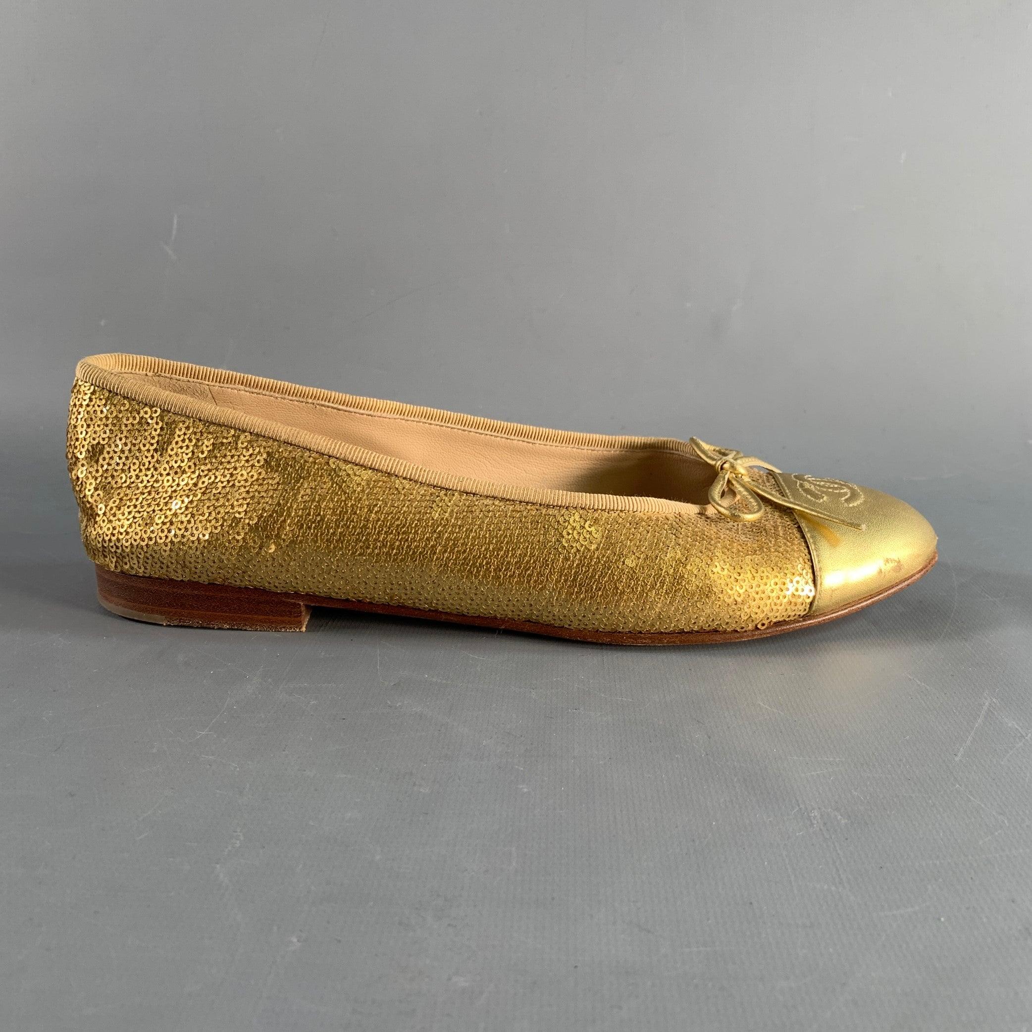 CHANEL ballet flats in a metallic gold tone sequins material featuring chanel cc logo, gold tone bow detail, and slip on closure. Made in Italy.Very Good Pre-Owned Condition. Minor signs of wear. 

Marked:   A C02819Outsole: 10.5 inches  x 3.25