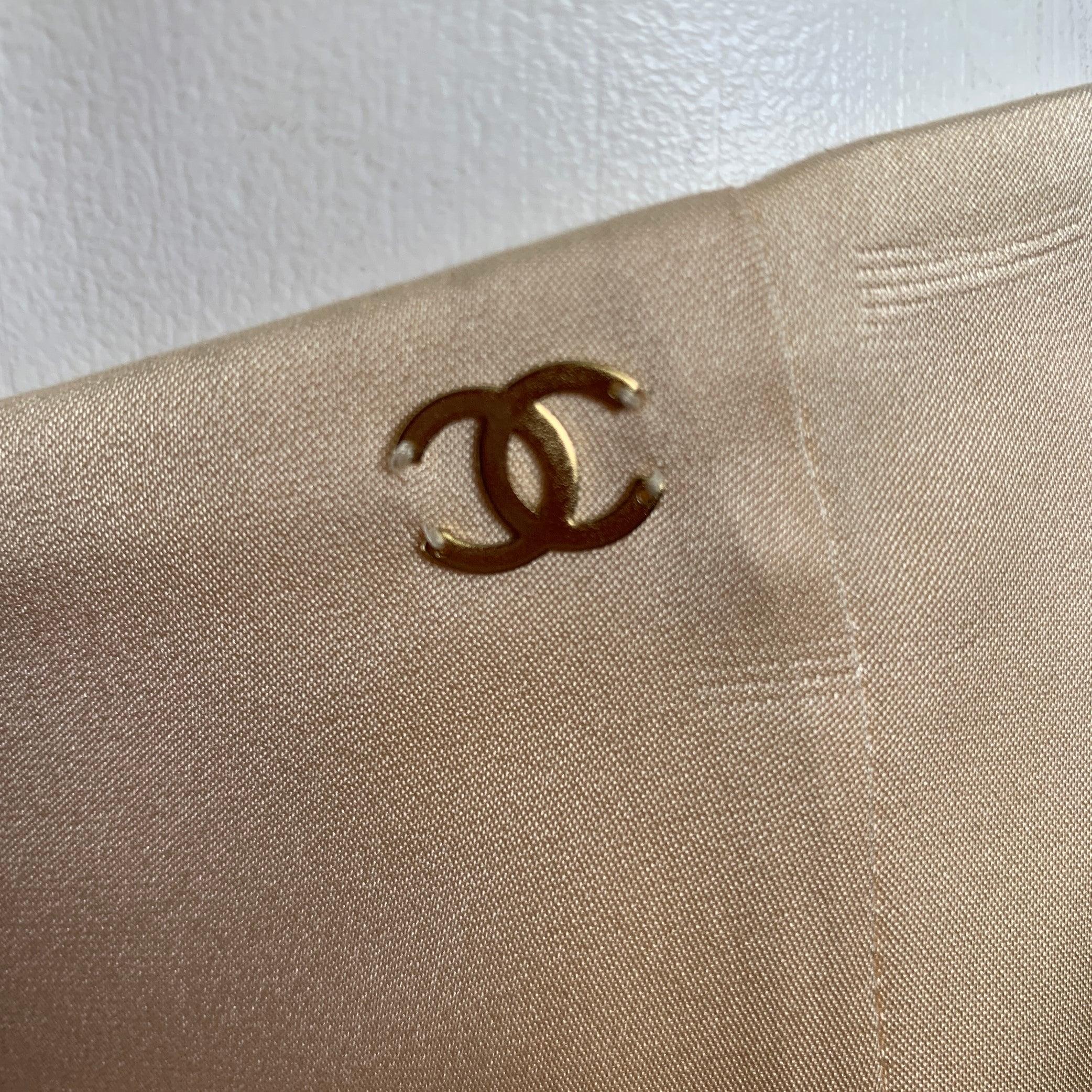 CHANEL skirt comes in a champagne silk featuring a layered style, gold tone logo detail, and a back zip up closure. Made in France. Very Good Pre-Owned Condition. 

Marked:   AI098 034 / 38 

Measurements: 
  Waist: 28 inches Hip: 40 inches Length: