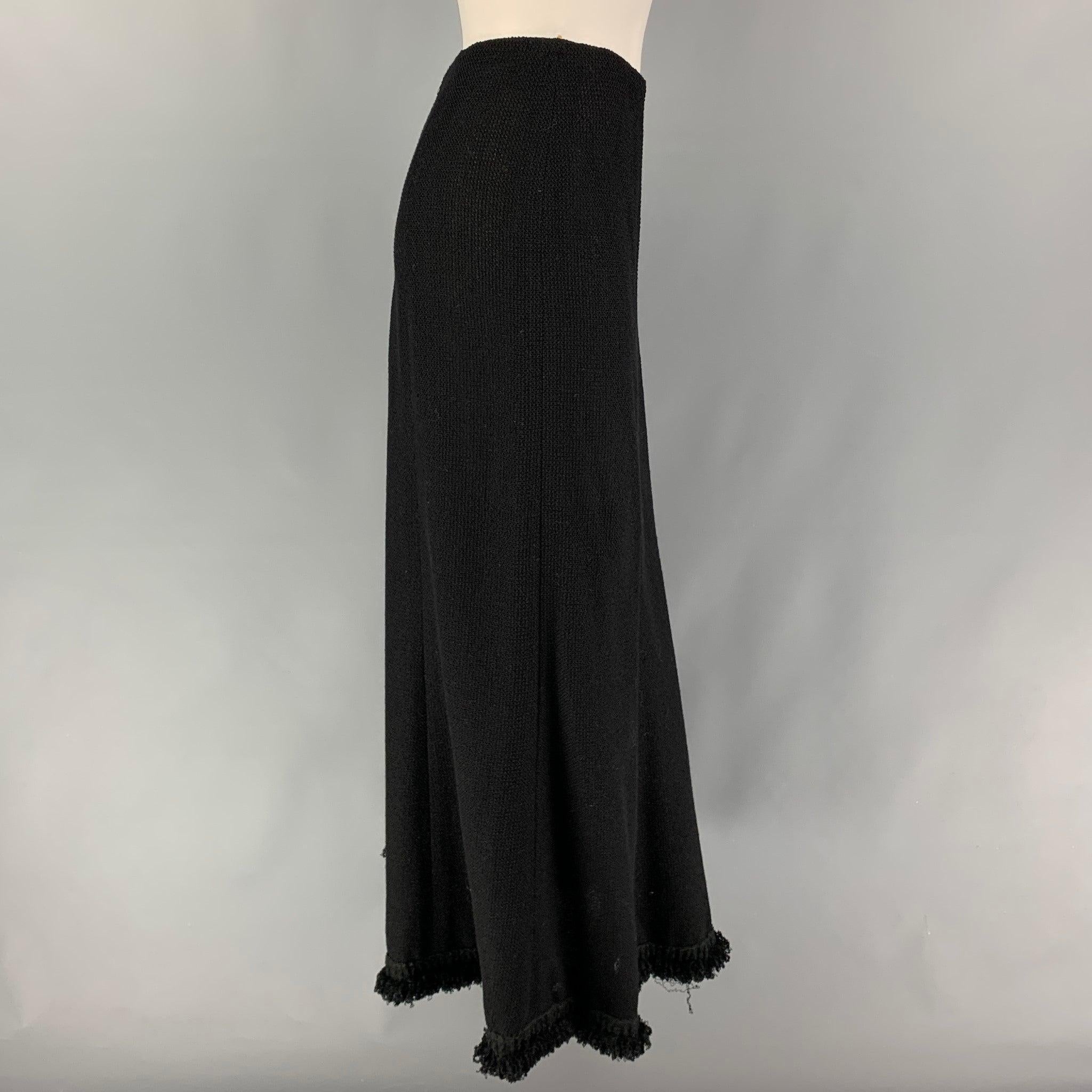 CHANEL 2003 skirt comes in a black textured wool blend featuring an a-line style, front small logo detail, ruffled hem, and a back zip up closure.
Very Good
Pre-Owned Condition. 

Marked:   03C / 94305 36 

Measurements: 
  Waist: 28 inches  Hip: 38