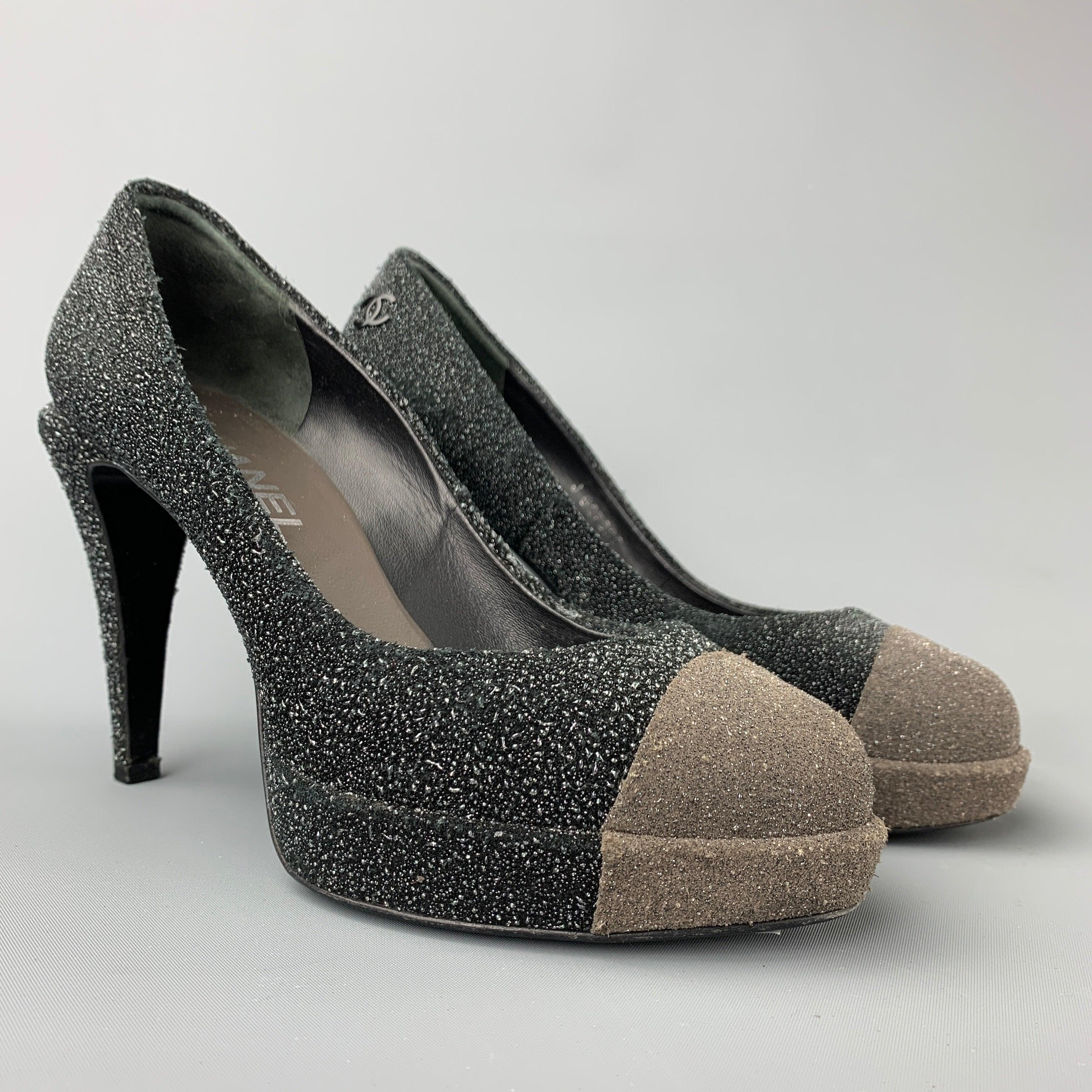 CHANEL pumps comes in a charcoal & grey sparkle textured material featuring a chanel logo detail, platform,and a stacked heel. Made in Italy.Very Good
Pre-Owned Condition. 

Marked:   EU 37 

Measurements: 
  Heel: 4 inches Platform: 0.5 inches 
  
