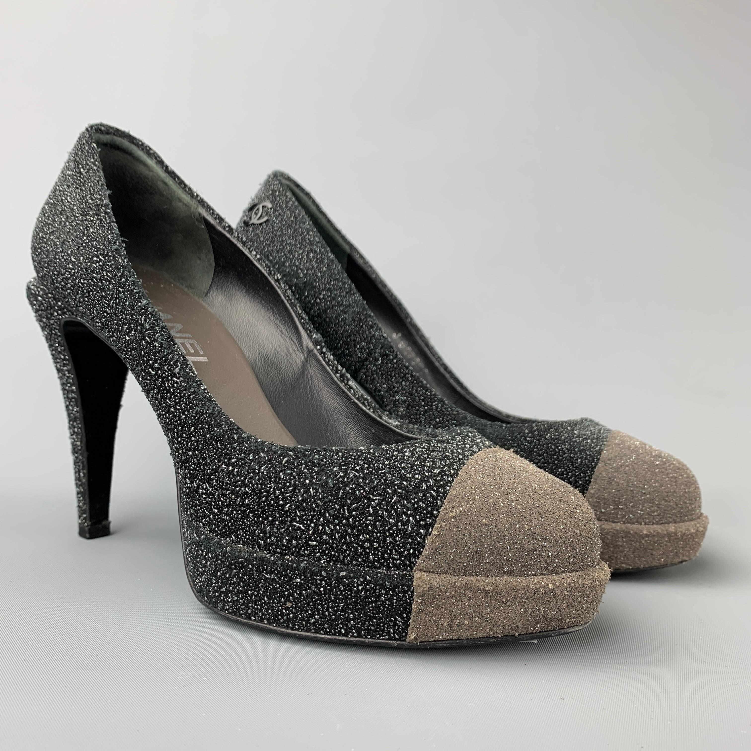 CHANEL pumps comes in a charcoal & grey sparkle textured material featuring a chanel logo detail, platform,and a stacked heel. Made in Italy.

Very Good Pre-Owned Condition.
Marked: EU 37

Measurements:

Heel: 4 in.
Platform: 0.5 in. 

