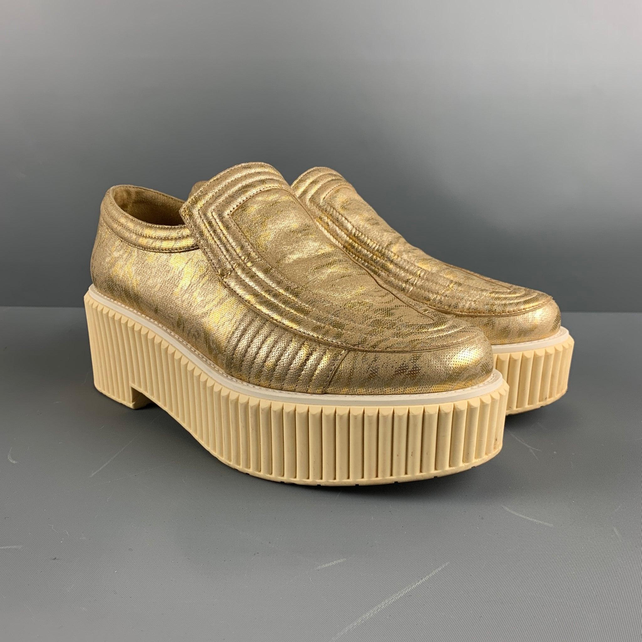 CHANEL platform comes in a gold tone jacquard featuring signature logo, rubber chunky soles, and a slip on design. Comes with Dust Bag. Made in Italy.Very Good Pre-Owned Conditions. 

Marked:   Outsole:10.75 inches  x 4 inches 
  
  
 
Reference: