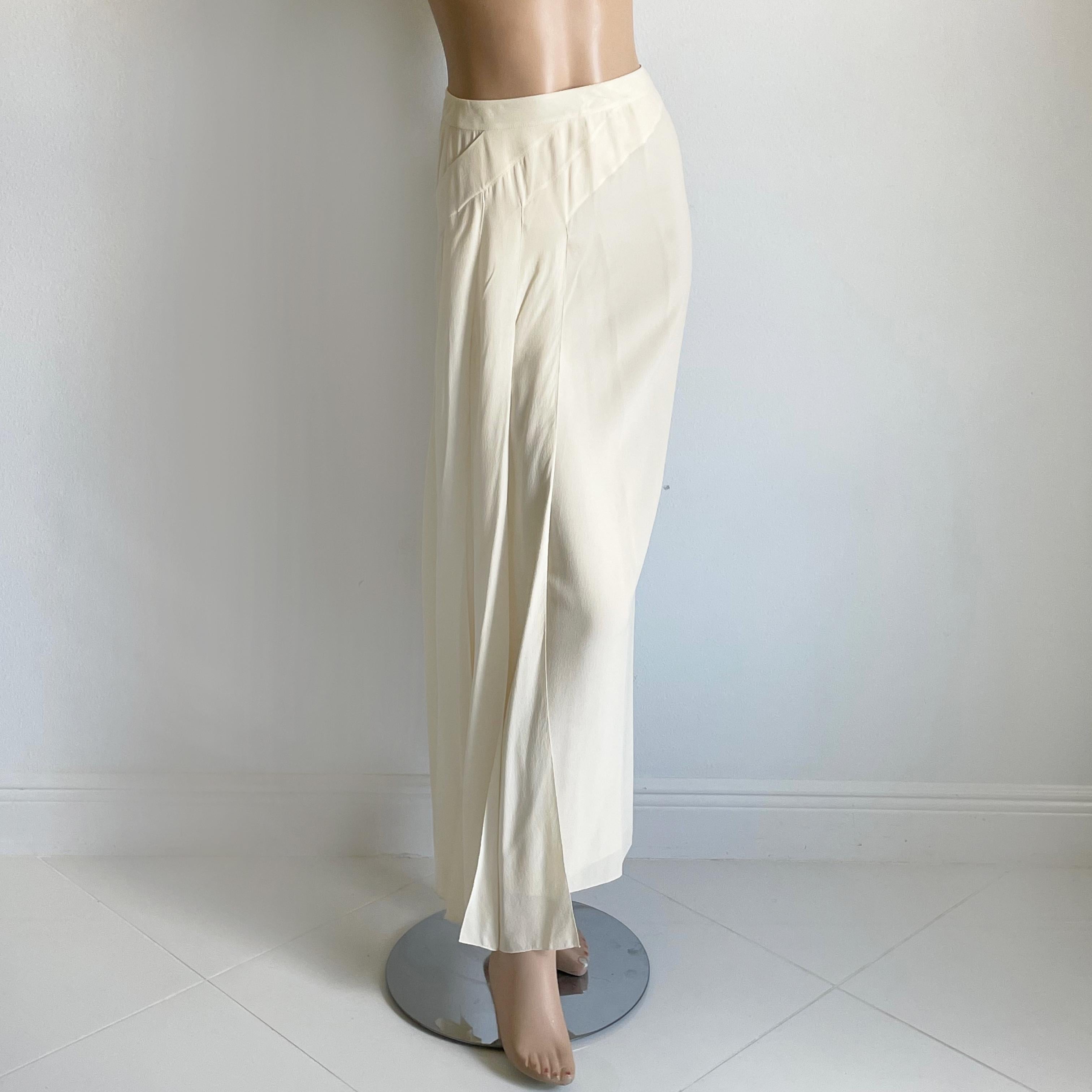 This preowned long skirt was made by Chanel for their Spring 1999 collection.  Made from eggshell colored silk, it features long asymmetric panels on one side with a 12in vent underneath, which gives the skirt incredible movement when you walk. 