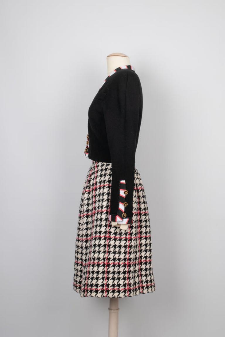 Chanel - (Made in France) Skirt suit composed of a black crepe jacket trimmed with big grain, and a wool skirt with houndstooth patterns. No size nor composition label, it fits a 36FR. 1987-1988 circa Haute Couture Collection.

Additional