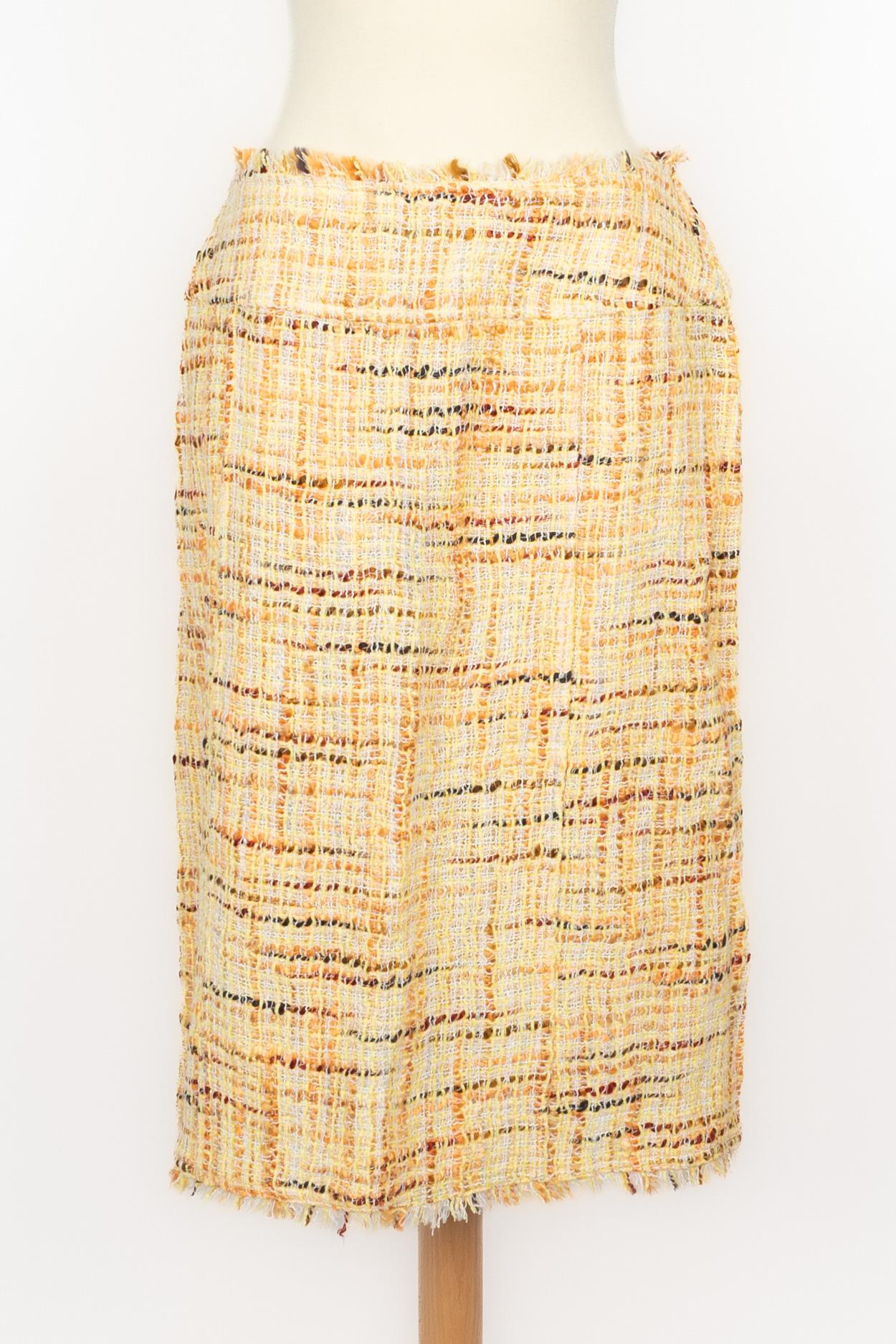CHANEL - (Fabricado en Francia) Traje de tweed muy fino compuesto por una falda y una chaqueta, en tonos amarillos, naranjas y marrones. Botones de resina decorados con logotipos cc de metal plateado. Talla 40FR indicada. Colección Primavera-Verano