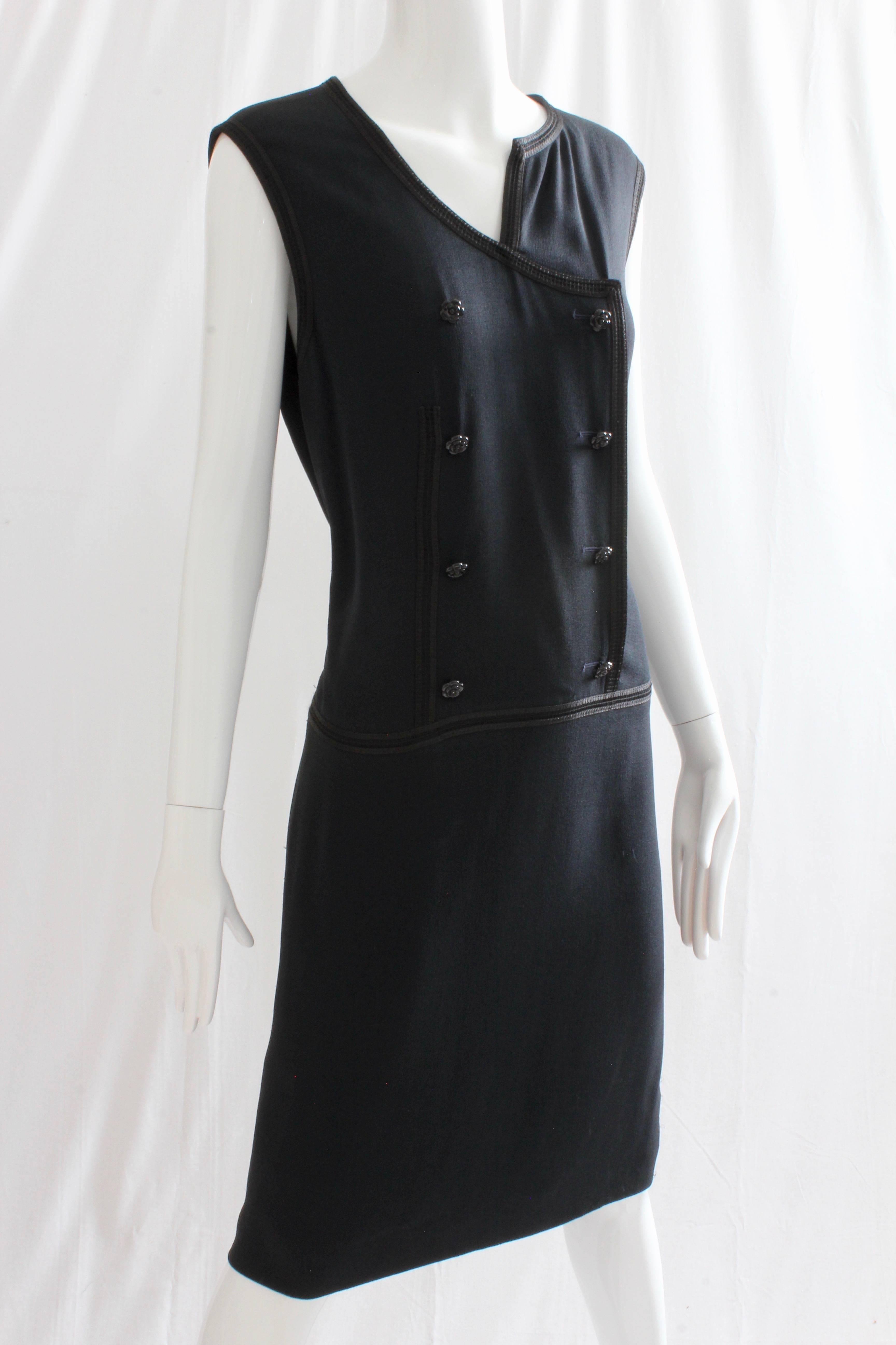 This chic little dress was made by Chanel for their 2002 collection.  Made from a navy crepe, it features an asymmetric collar, black lace trim and fastens with black Camellia buttons.  Fully-lined in navy silk.  In very good condition given its age