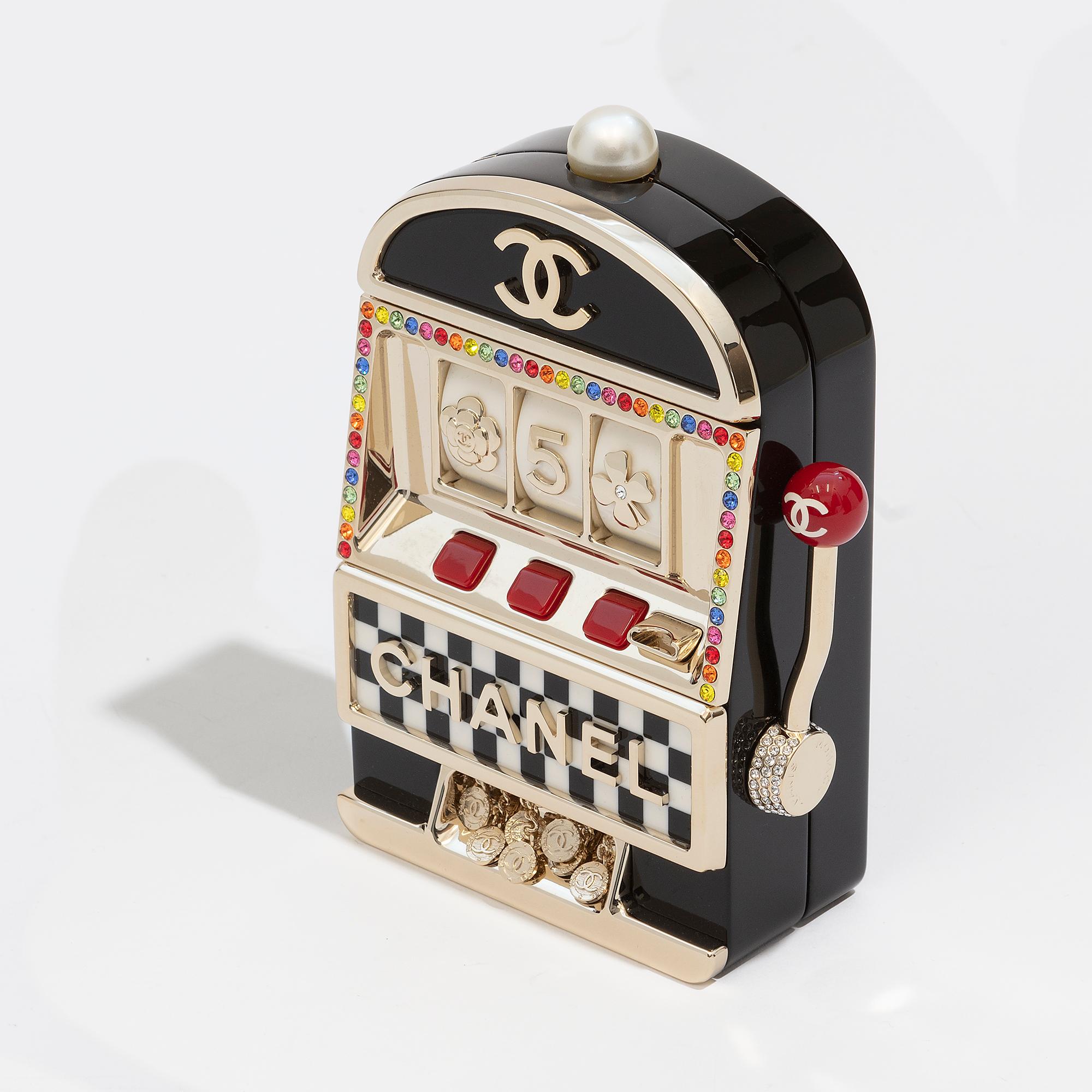 The Casino Minaudière Evening Clutch Bag from Chanel is an exclusive and highly sought-after piece from the 2023 Cruise collection. It boasts a slot machine design, rainbow crystals decoration, and gold hardware, and comes with a chain crossbody