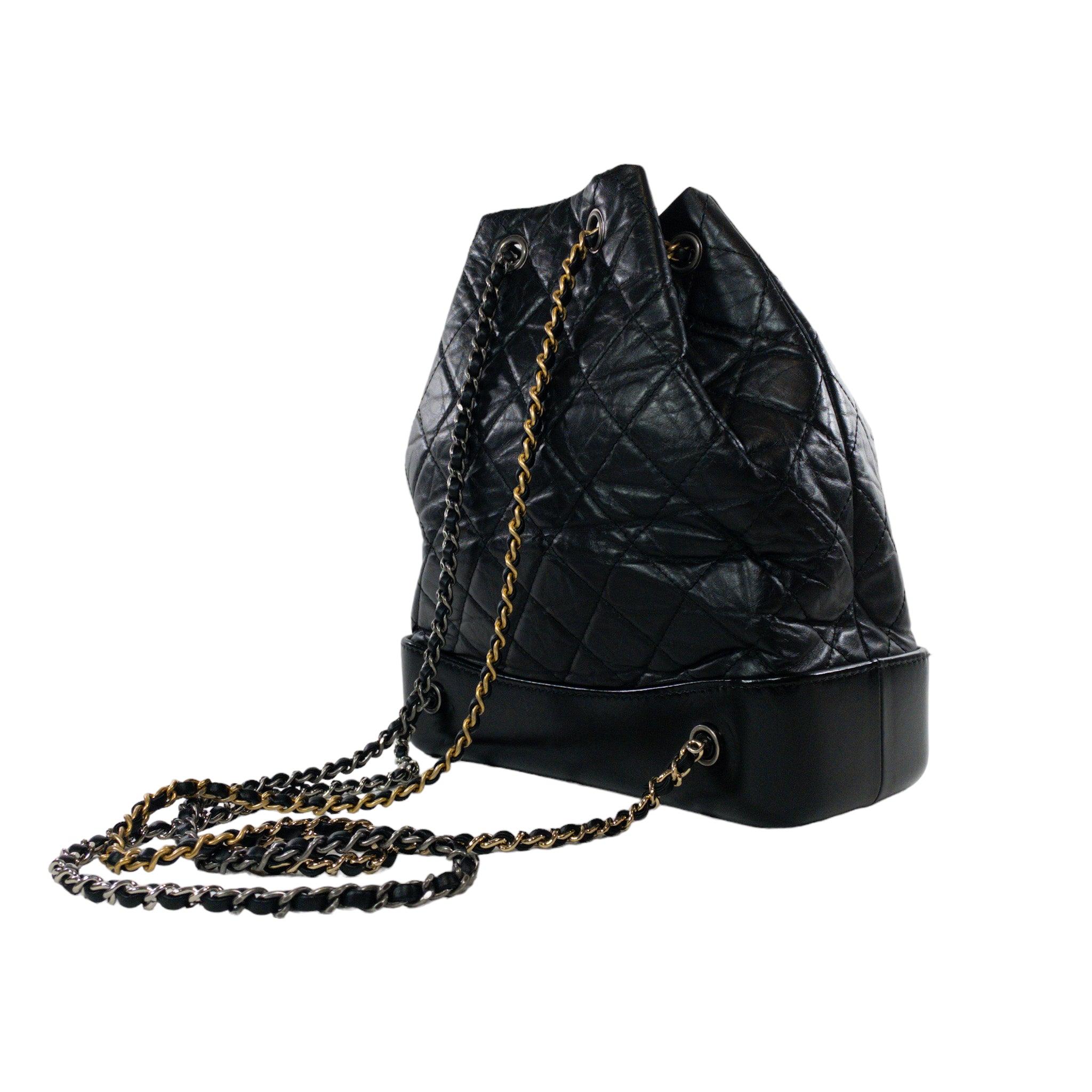 Chanel Kleiner schwarzer Gabrielle-Rucksack

Dies ist eine authentische Chanel Gabrielle kleinen Kordelzug Rucksack. Schwarzes, gestepptes Leder mit glasiertem, strukturiertem Boden. Mehrfarbige gewebte Kettenbeschläge. Ruthenium CC im Vordergrund.