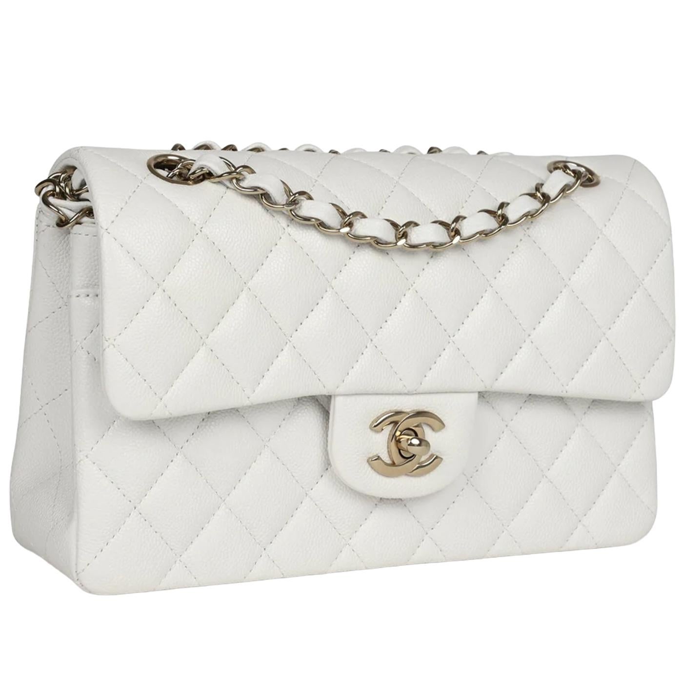 Diese kleine Chanel Classic Double Flap Tasche ist aus weißem Kaviarleder mit hellgoldfarbenen Beschlägen und verfügt über eine Frontklappe mit dem charakteristischen CC-Drehverschluss, eine Halbmondtasche auf der Rückseite und einen verstellbaren,