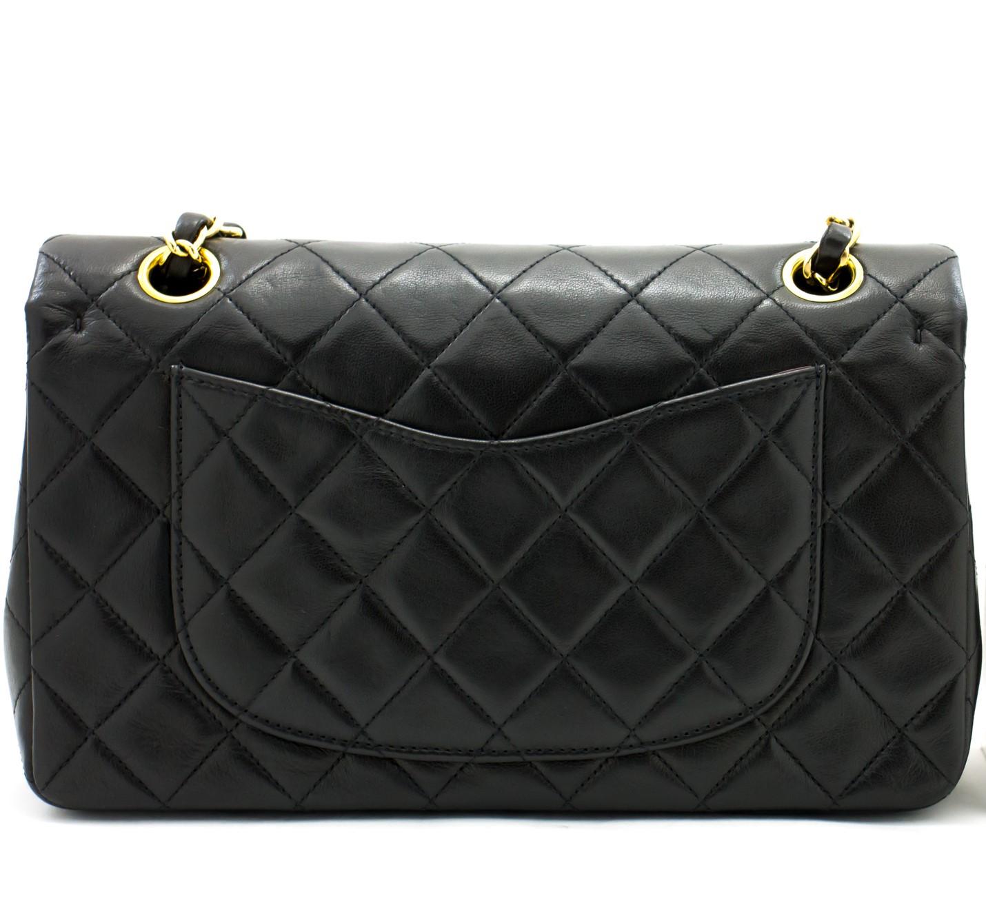 This iconic Chanel 9-inch double flap bag from 1997- 1999 has been crafted from quilted black lambskin and features a double flap. The front flap has been finished with the classic CC logo twist lock, with the second flap featuring a stud closure