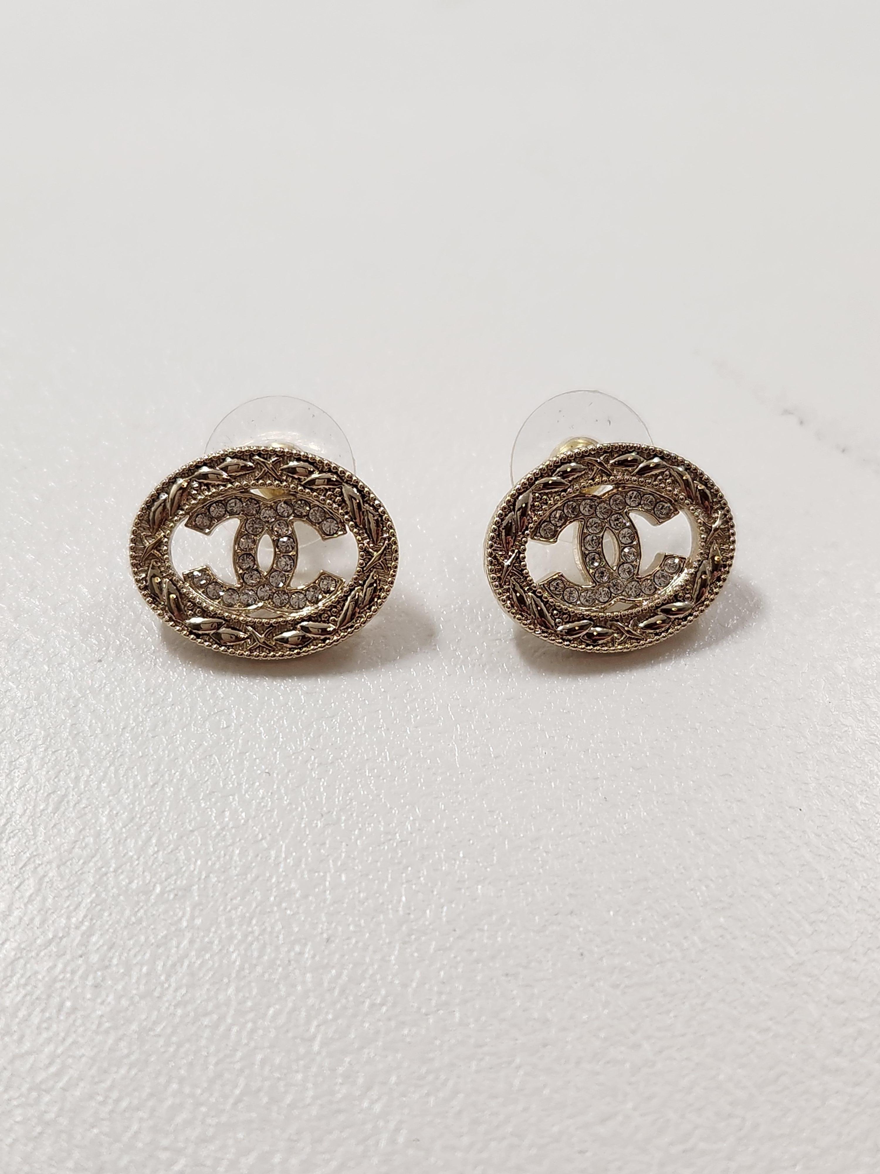 Enhance your elegance with the timeless allure of the Chanel Small Rhinestone CC Oval Stud Earrings B22. Crafted with meticulous attention to detail, these earrings showcase Chanel's signature interlocking CC logo adorned with delicate rhinestones,