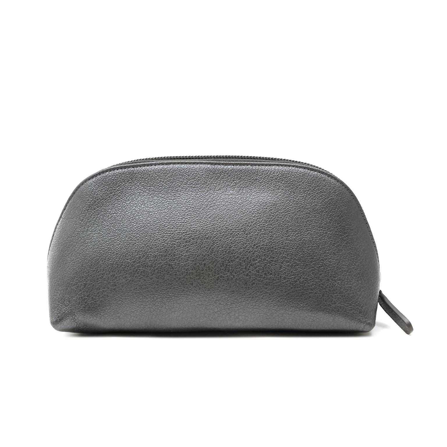 This authentic Chanel Small Slate Grey Camellia Pouch is in excellent plus condition.  Perfect for cosmetics or other small necessary items, this chic pouch is a great find.
Slate grey domed leather pouch with zippered top opening.  Clean fabric