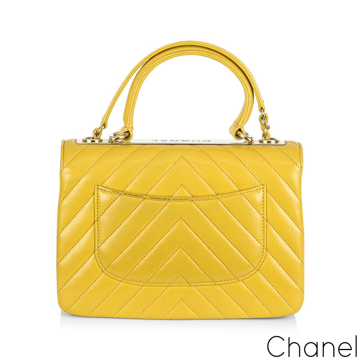 A stylish yellow Chanel Small Trendy CC Flap Bag. The exterior of this Trendy is crafted with yellow lambskin leather in the signature chevron style stitching and gold tone hardware. It features a front flap with signature CC turnlock closure, half