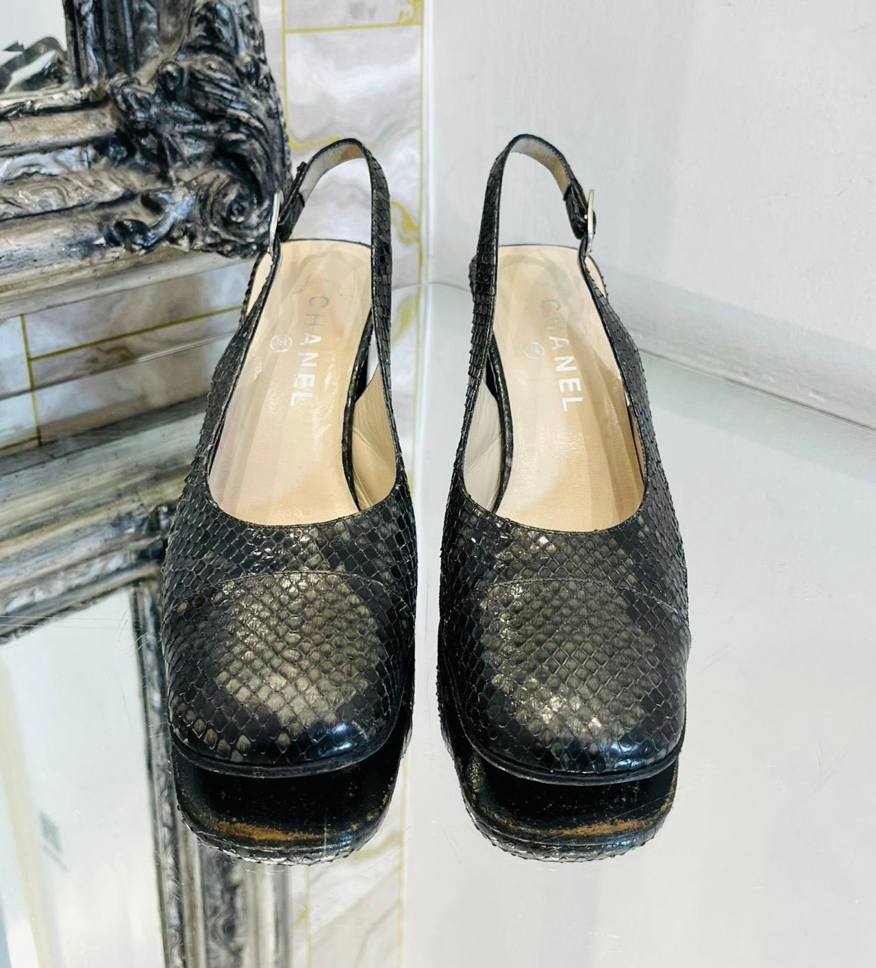Chanel Snakeskin Slingback Pumps

Black heels crafted from snakeskin leather and designed with greenish grey reflection effect.

Featuring square toes and high block heel styled with silver 'Chanel' engraved detail.

Having 'CC' logo adjustable,