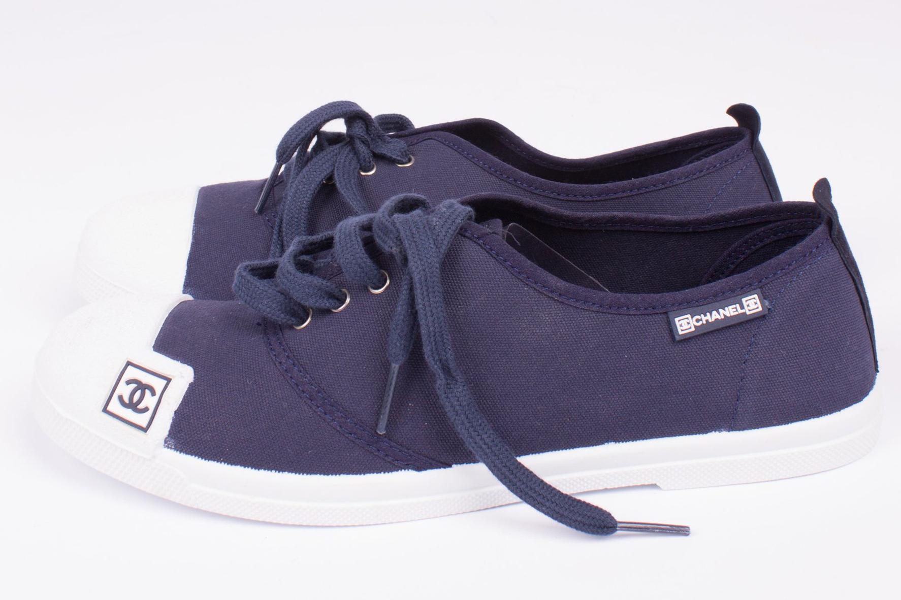 Sneakers by Chanel in dark blue canvas with a white rubber toe and sole.

A lace on the front and a white CC-logo on the tongue of the shoe. A dark blue CC logo on the toe. Heelheight 2 centimeters, lined with dark blue canvas.

New and never been