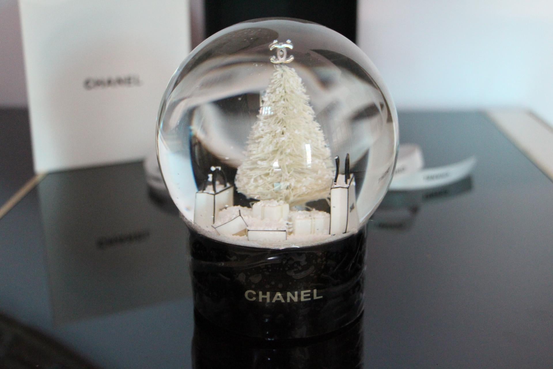 This magnificent globe was made in 2013 as a special edition for limited Chanel VIP customers.
It features a white Christmas tree and Chanel gift bags.
Many very mobile snow flakes.
It is a very decorative piece for Chanel lovers, a must