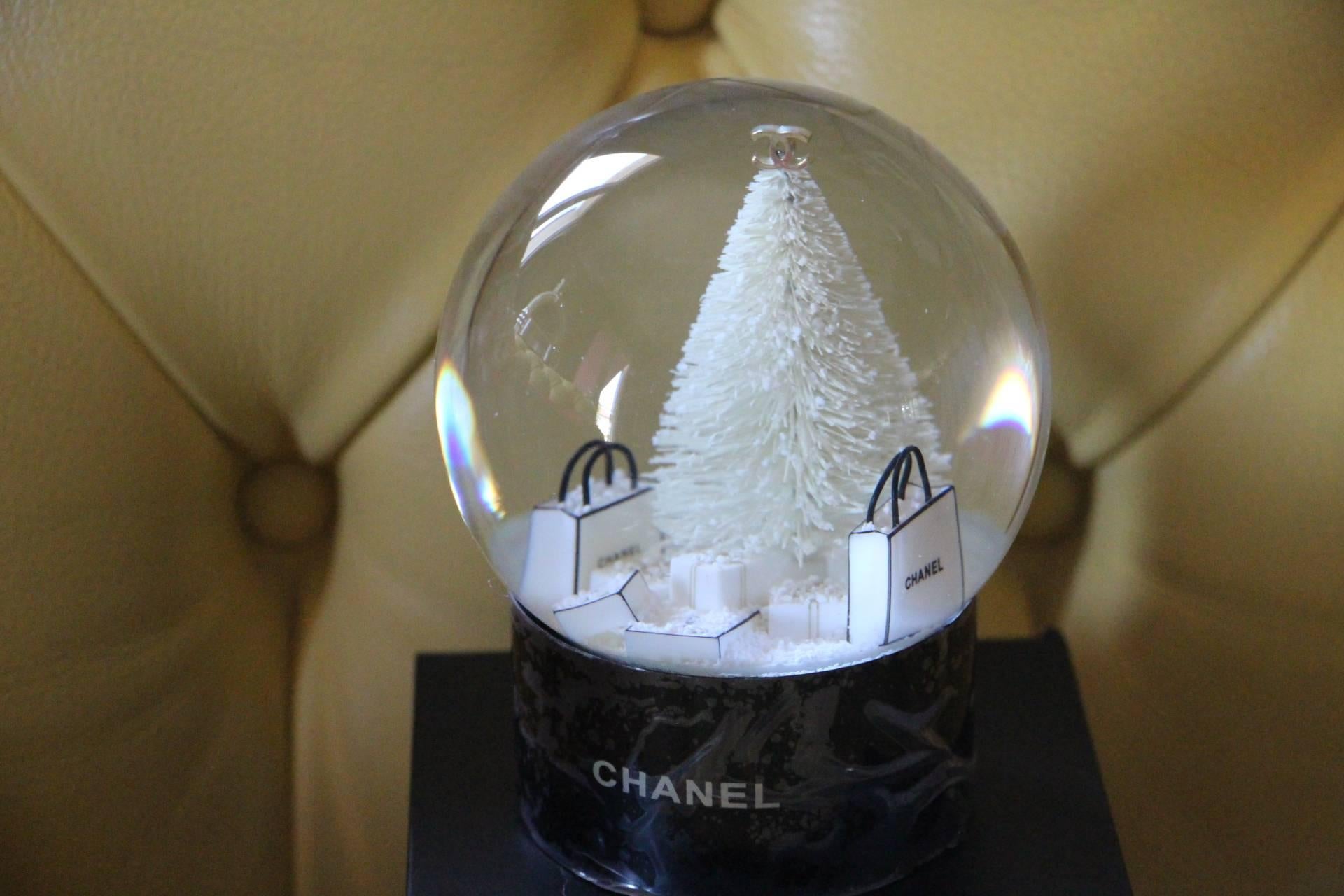 This magnificent globe was made in 2013 as a special edition for limited Chanel VIP customers.
It features a white Christmas tree and Chanel gift bags.
Many very mobile snow flakes.
It is a very decorative piece for Chanel lovers, a must