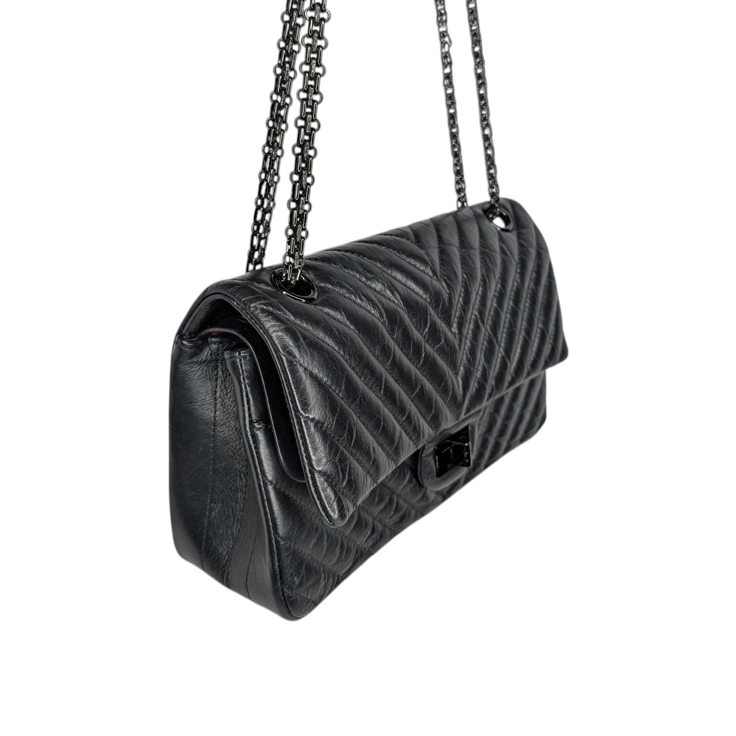Questa elegante borsa a tracolla è realizzata in pelle di vitello nera metallizzata trapuntata con motivo chevron. La borsa è dotata di tracolle a catena Bijoux lucide con chiusura frontale nera Mademoiselle. La patta frontale si apre su una patta