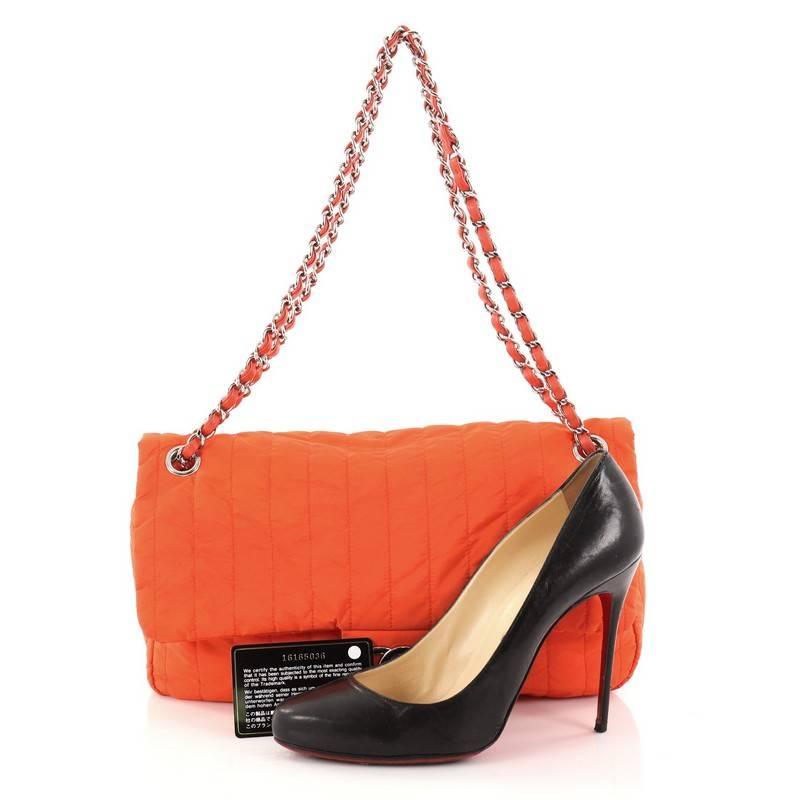 This authentic Chanel Soft Shell Flap Bag Vertical Quilted Nylon Jumbo is a limited edition piece from the brands' Spring 2012 Collection. Crafted from red orange quilted nylon, this chic bag features woven-in leather chain strap, front flap with CC