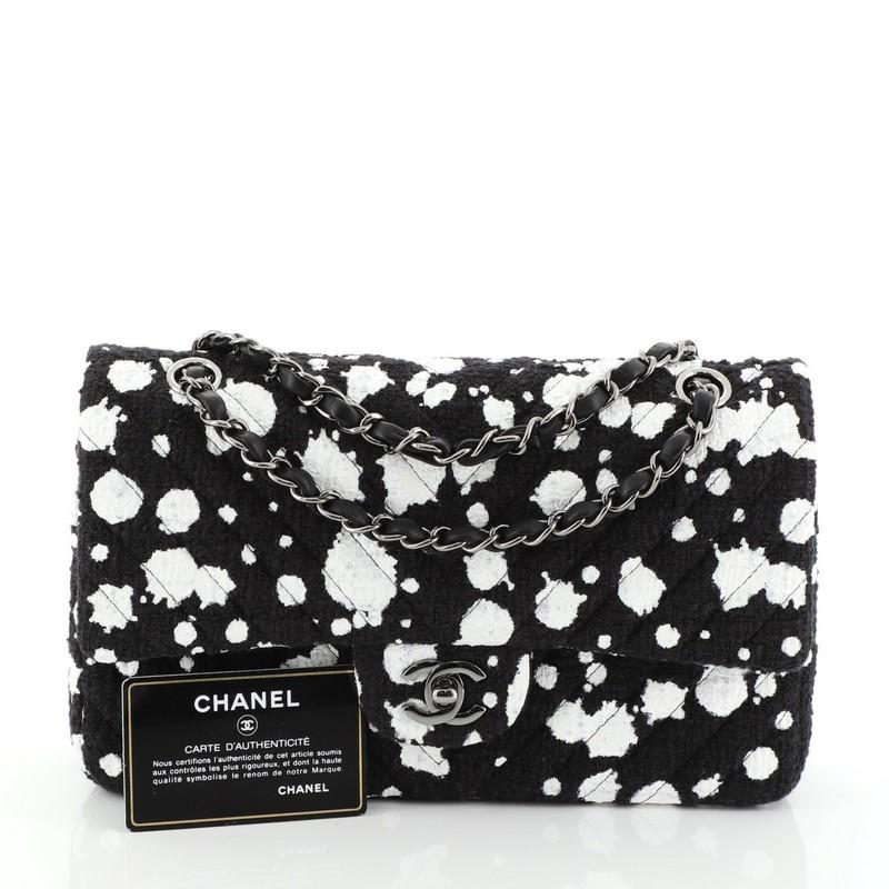 This Chanel Splatter Paint Classic Double Flap Bag Tweed Medium, crafted in black tweed blended with a white splatter paint design, features woven-in leather chain strap, exterior back pocket, chevron-style stitching and gunmetal-tone hardware. Its