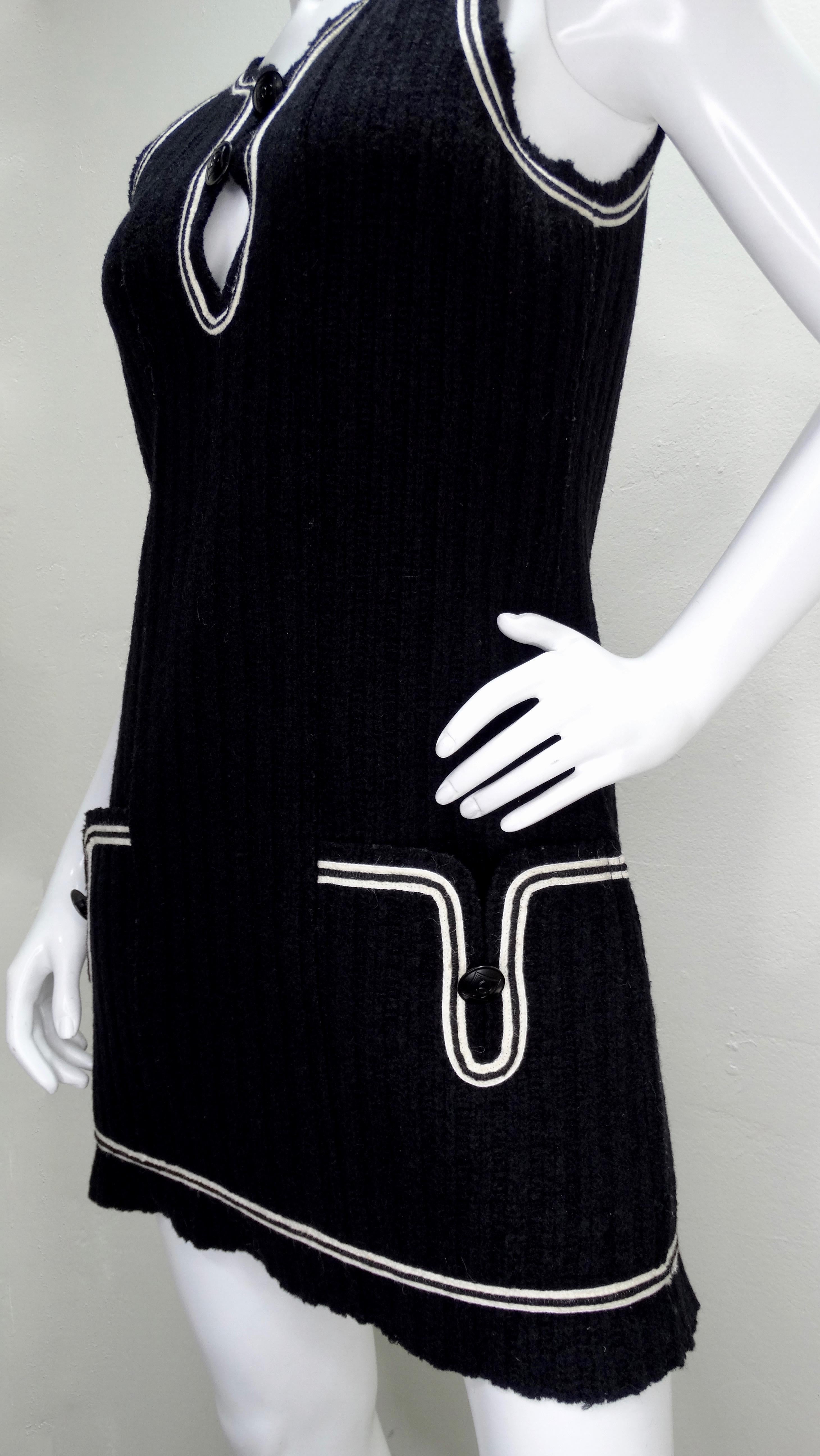 For all the Chanel lovers! Circa 2007 from their Fall/Winter Sport collection, this mini dress brings back the 90s Chanel Sport aesthetic and features black wool with white pipping, a deep v-neck, two front pockets, and large matte black CC embossed