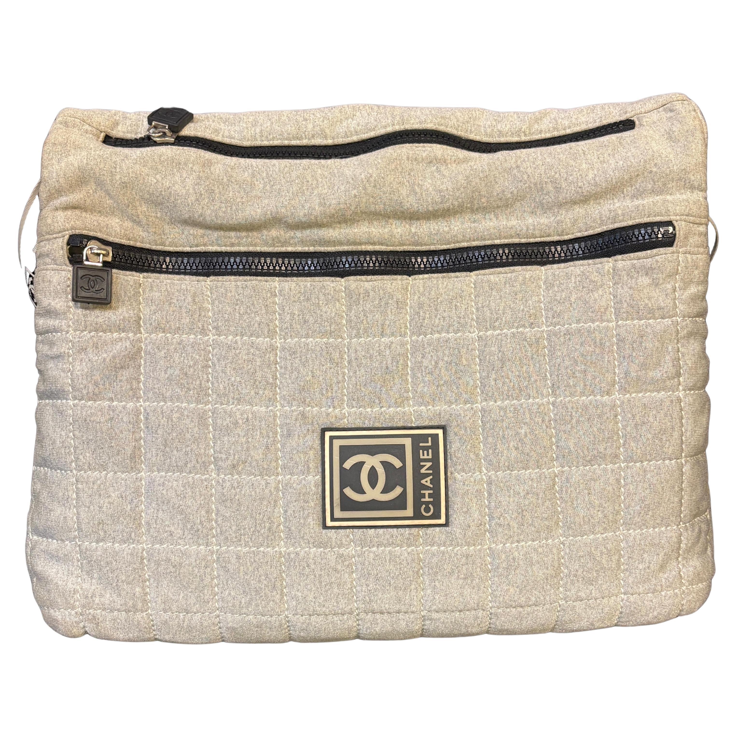Bolso messenger de tela Chanel en tejido gris. Bolsa única con muchos compartimentos. Logotipo completo de Chanel en la correa. Hay una pequeña mancha amarillenta en la tela, pero no se nota demasiado. Pequeñas pelusas en el tejido. La cremallera es
