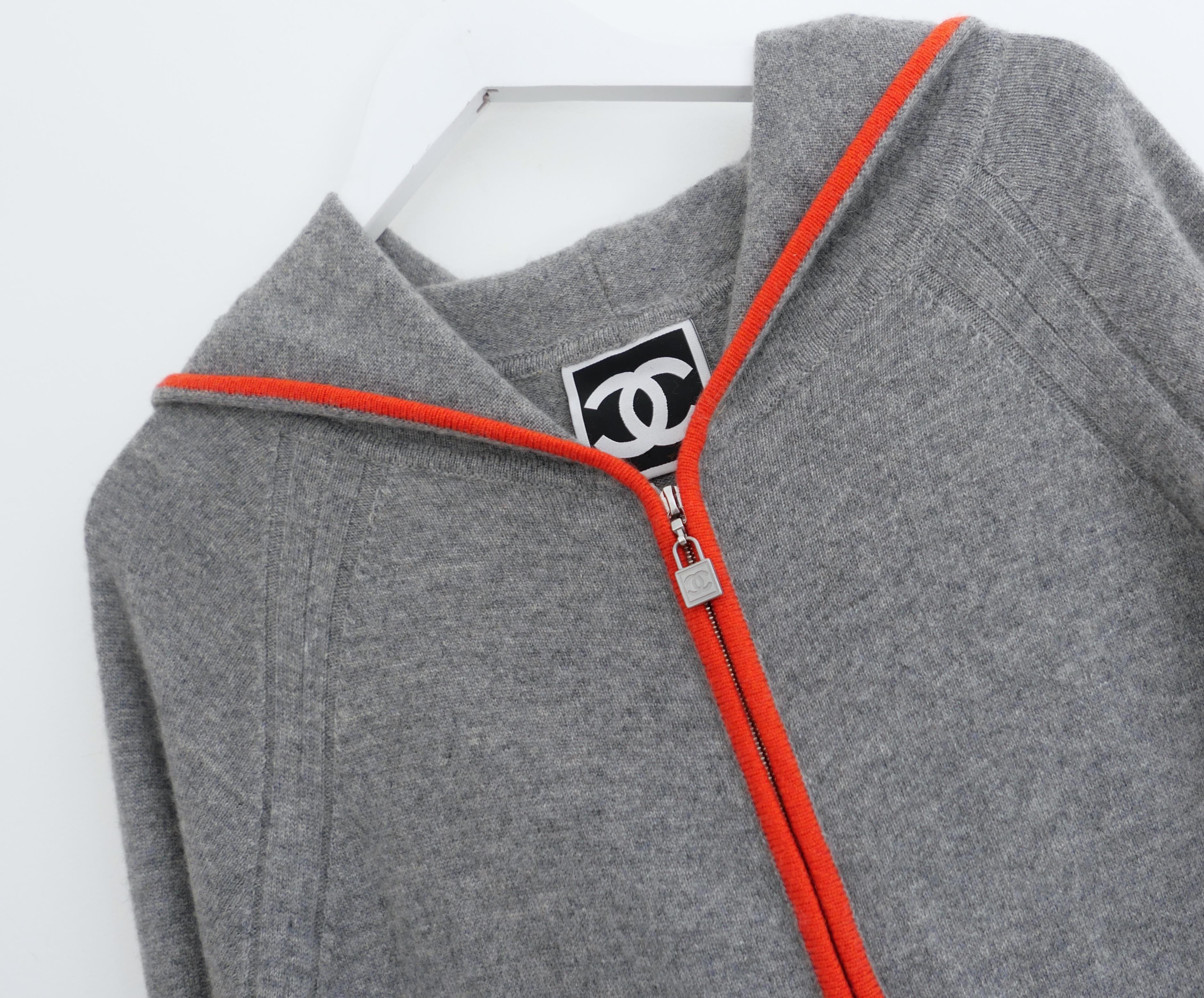 Super rare, unworn Chanel Sport Line 2009 09P cashmere zip front long cardigan jacket. Made from kitten soft, mid weight grey cashmere with bright orange trims and sporty navy and white banding to the back. It has a loose fit with low set slit