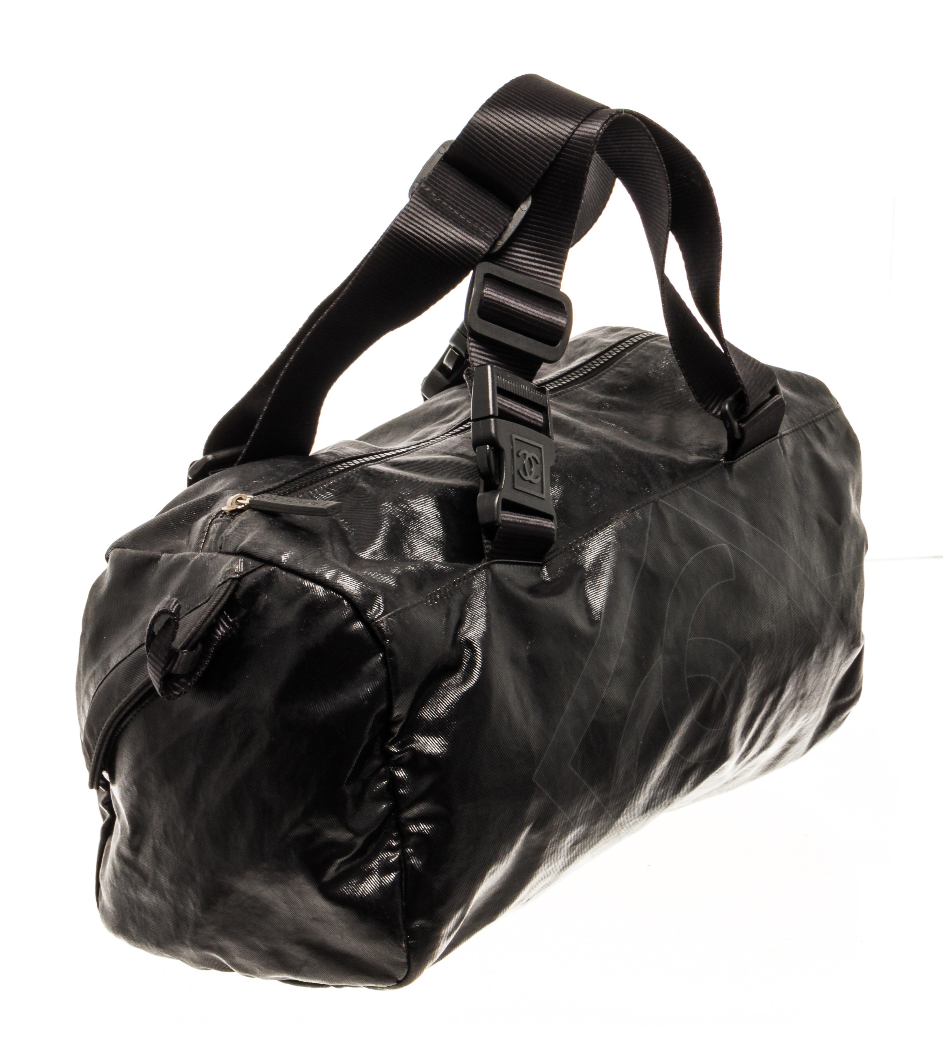 Chanel Sport Line nylon duffel bag with flat adjustable top handles, decorative buckles, interlocking Chanel logo, one interior zip pocket, and zipper closure.

80499MSC