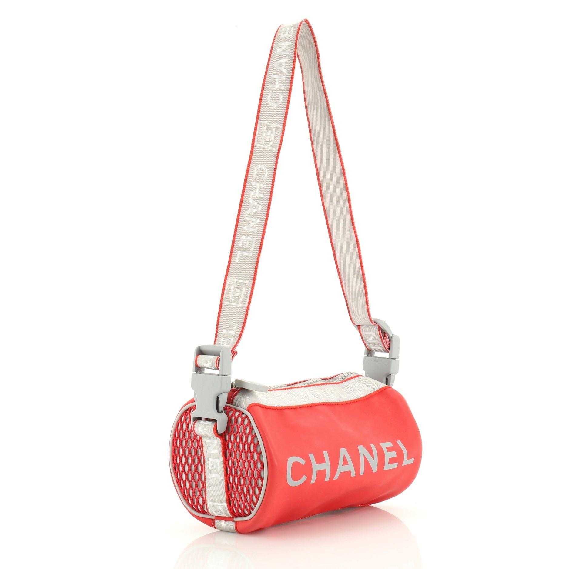 This Chanel Sports Line Roll Shoulder Bag Coated Canvas Small, crafted from gray and red coated canvas, features front printed CC logo and silver tone hardware. Its zip closure opens to a gray fabric interior. Authenticity code reads: